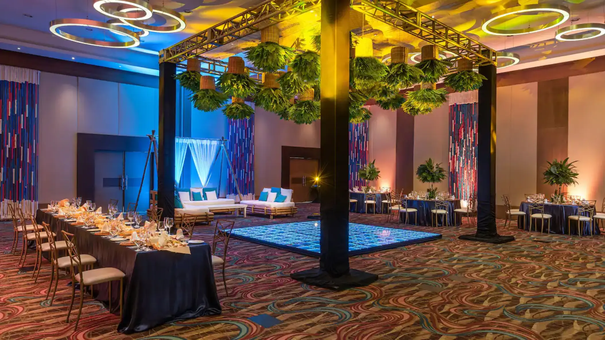 Indoor ballroom wedding reception with dance floor and greenery at Hyatt Ziva Cancun