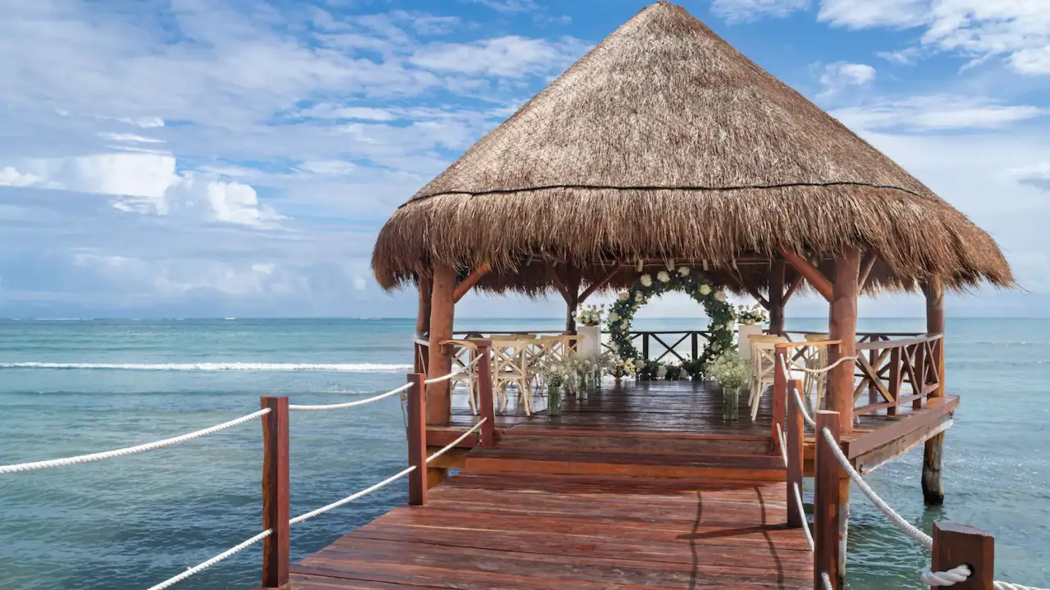 Overwater gazebo wedding ceremony with floral arch at Hyatt Ziva Cancun