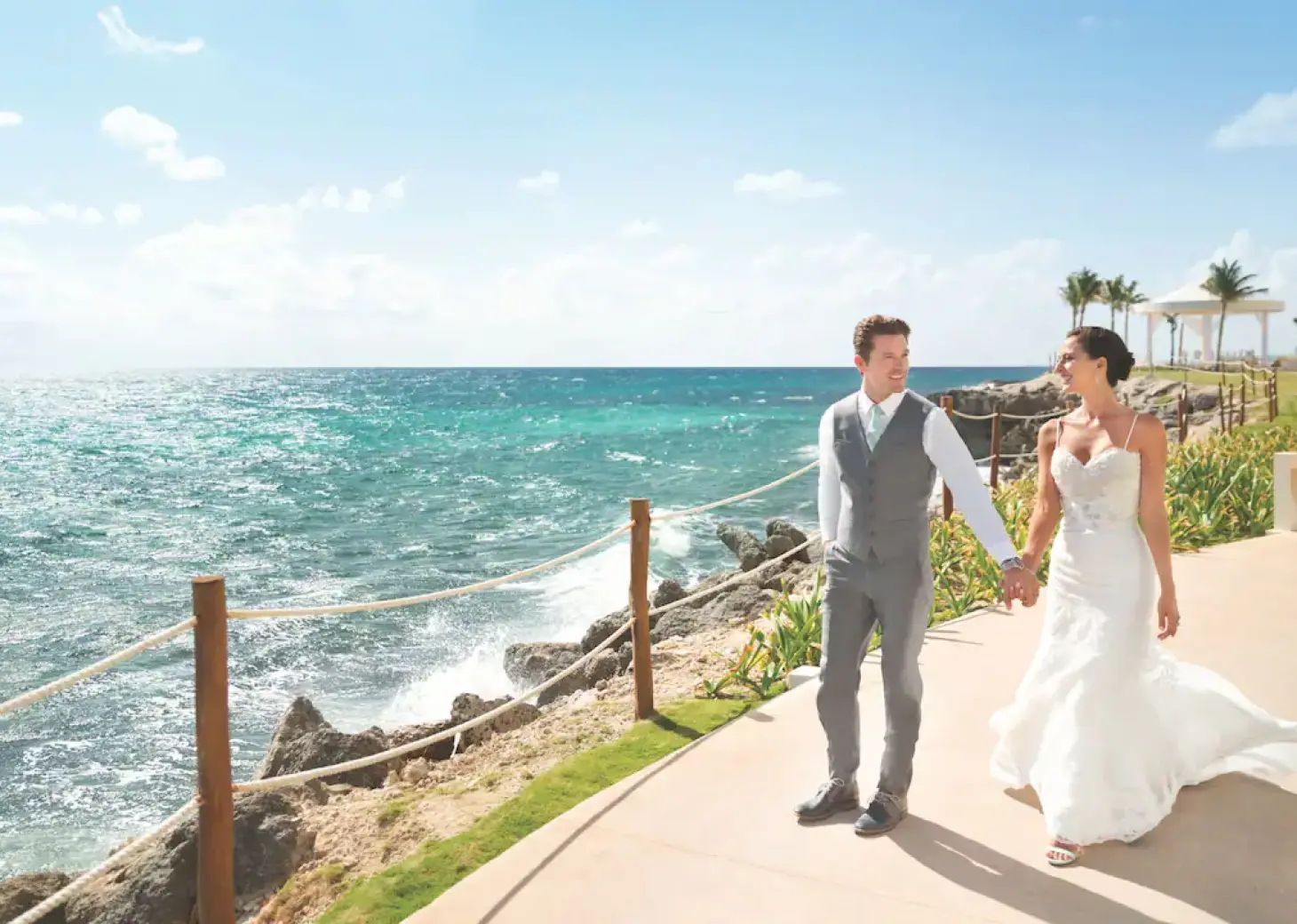 Newlywed couple walking along the oceanfront path at Hyatt Ziva Cancun