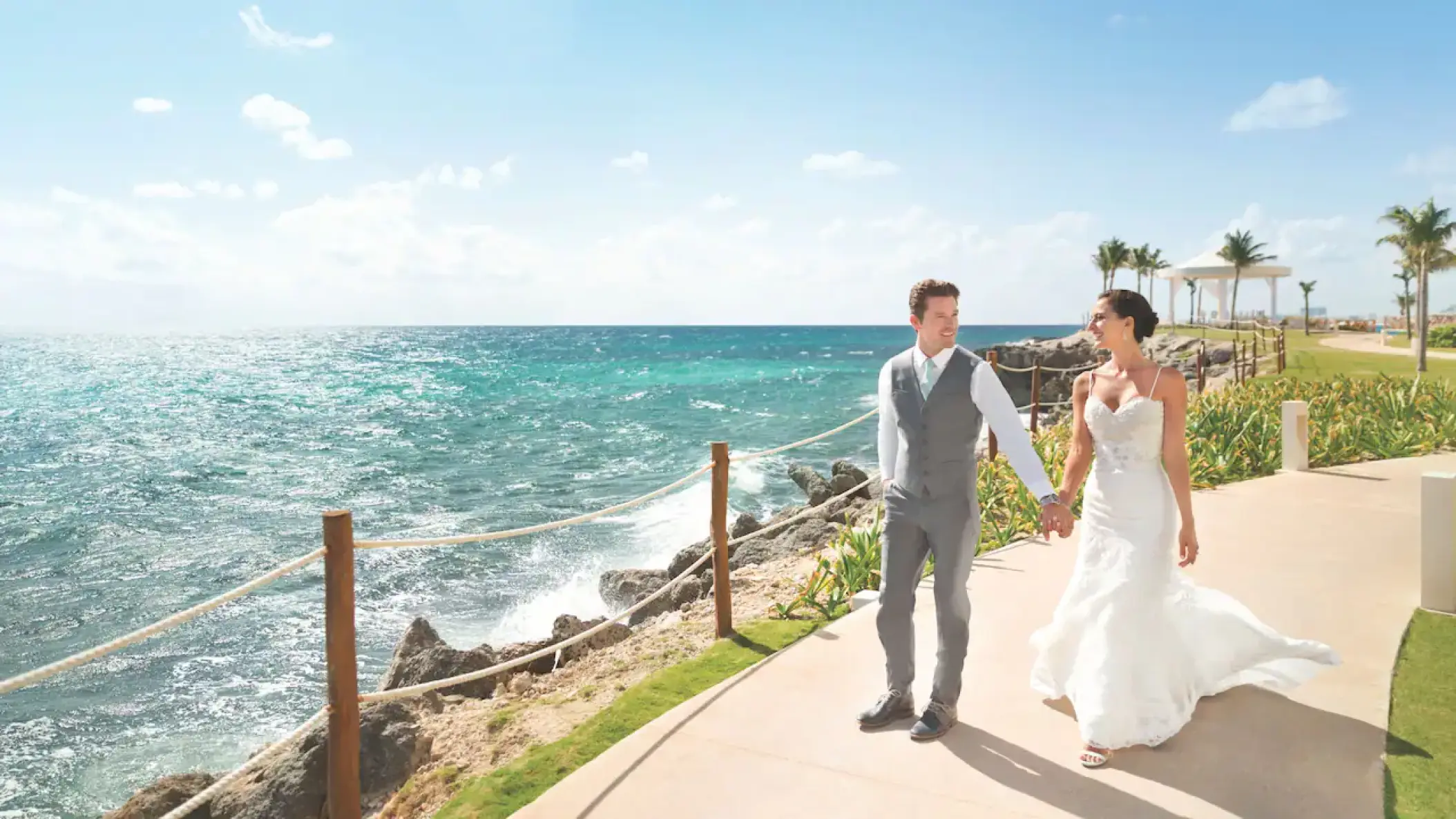 Newlywed couple walking along the oceanfront path at Hyatt Ziva Cancun