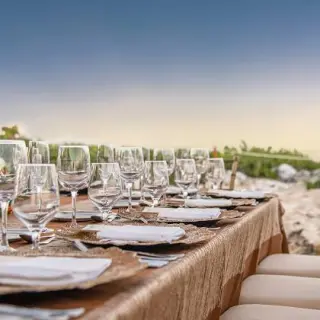 Wedding reception table with floral arrangements and glassware overlooking the lighthouse at Hyatt Ziva Cancun