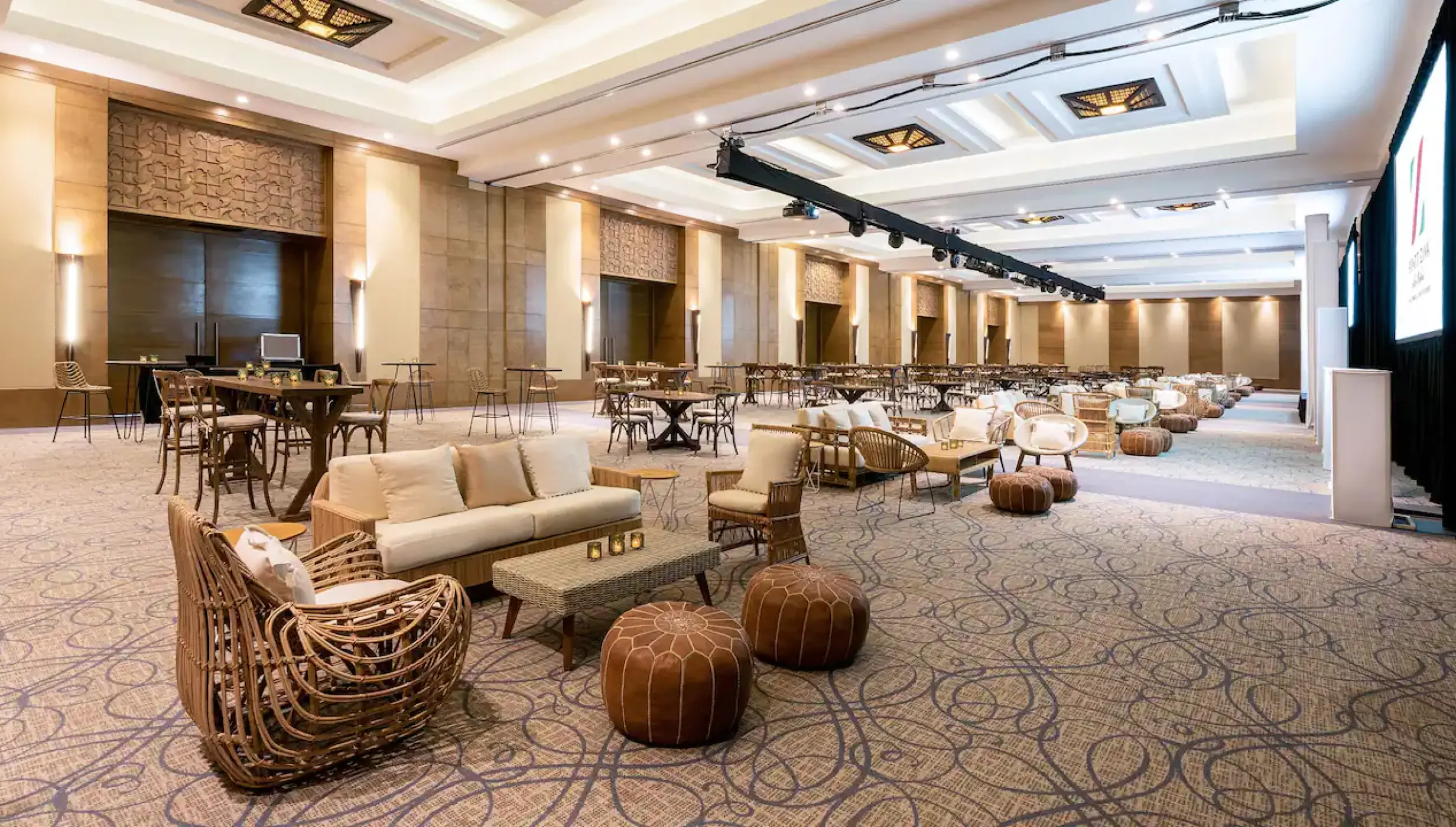 Indoor ballroom reception lounge with woven chairs and leather poufs at Hyatt Ziva Los Cabos, Cabo San Lucas
