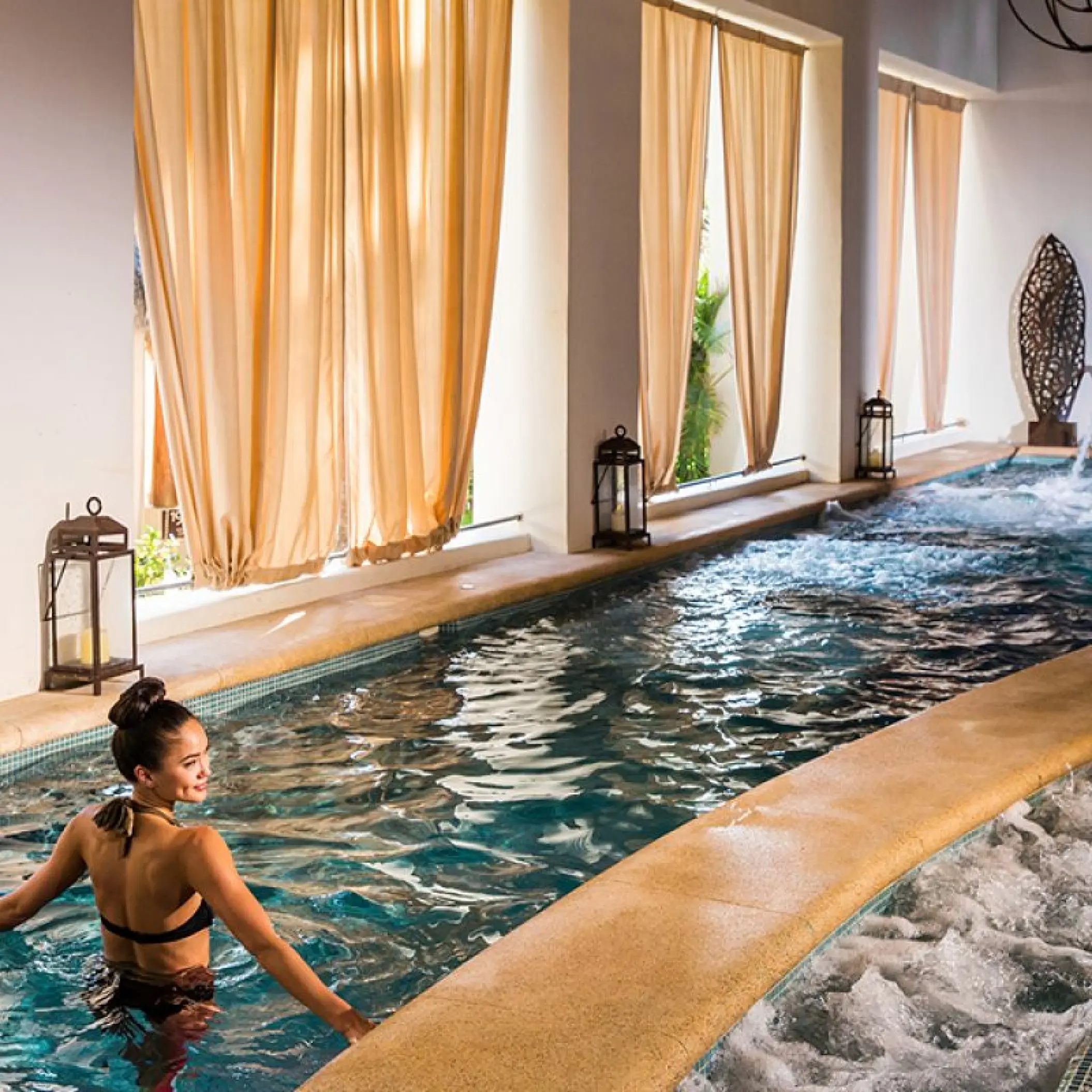 Woman in an indoor spa hydrotherapy pool at Hyatt Ziva Los Cabos, Cabo San Lucas