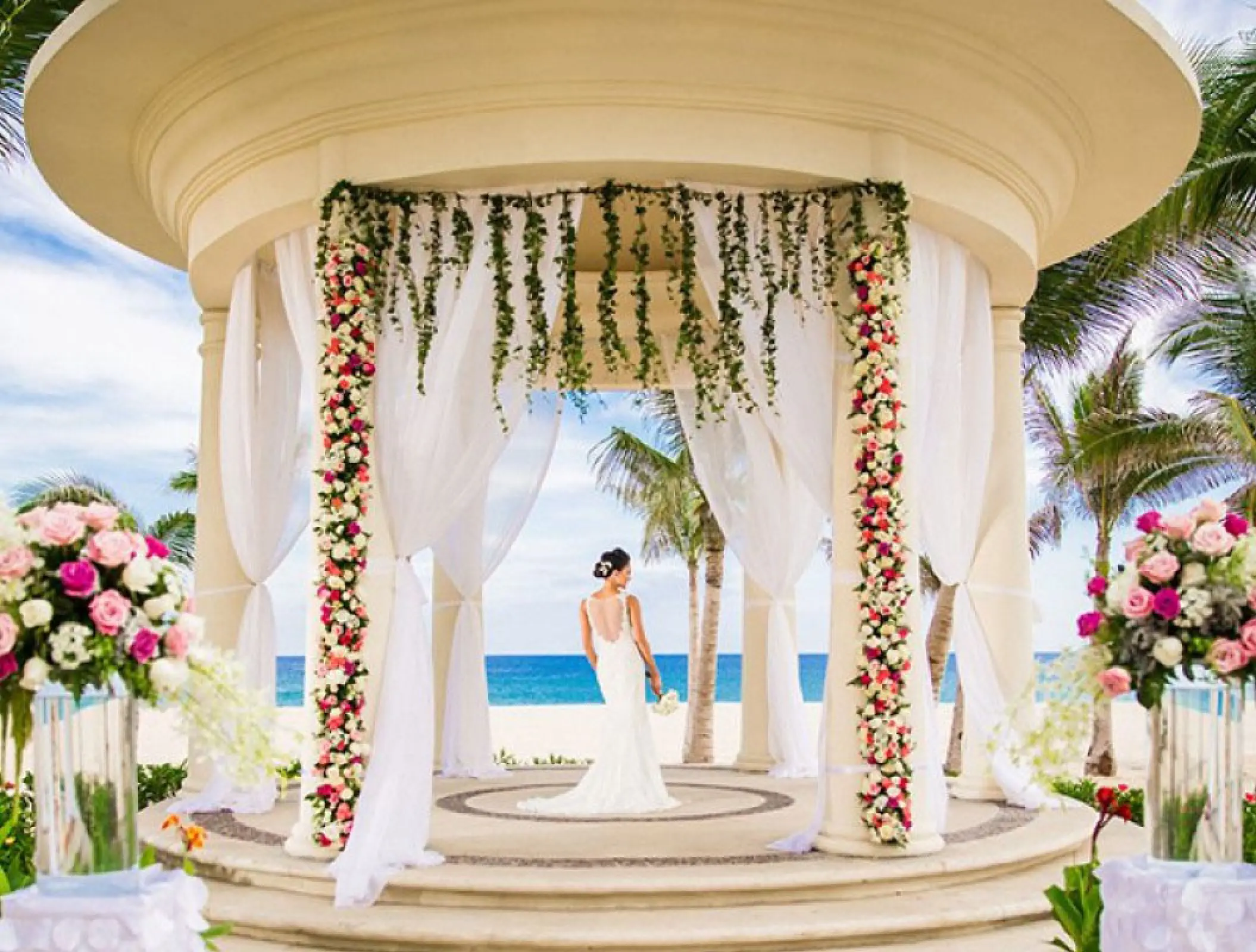 Bride in an oceanfront wedding gazebo decorated with floral garlands at Hyatt Ziva Los Cabos, Cabo San Lucas