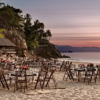 Beachfront wedding reception setup with wooden chairs at Hyatt Ziva Puerto Vallarta