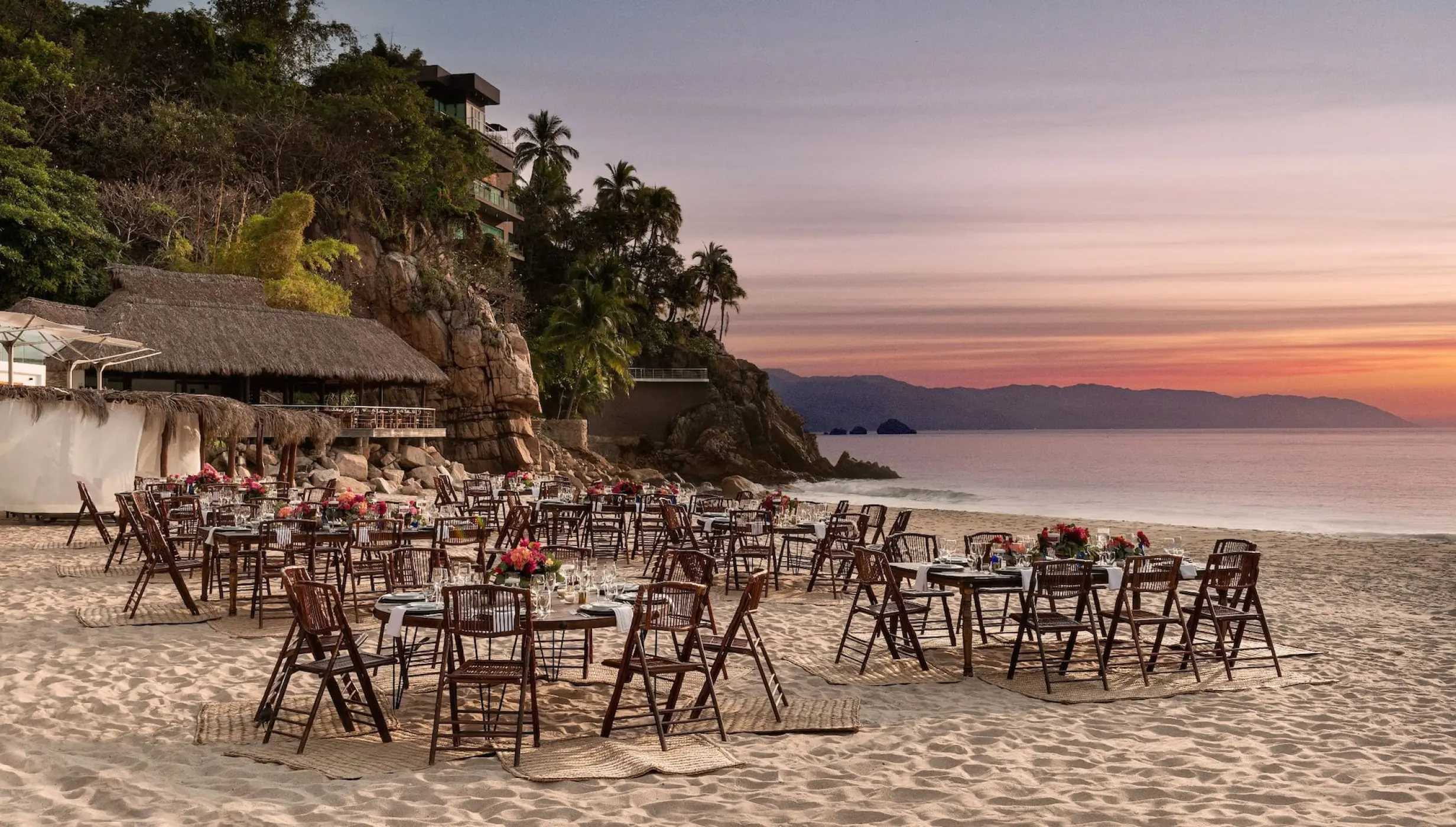 Beachfront wedding reception setup with wooden chairs at Hyatt Ziva Puerto Vallarta