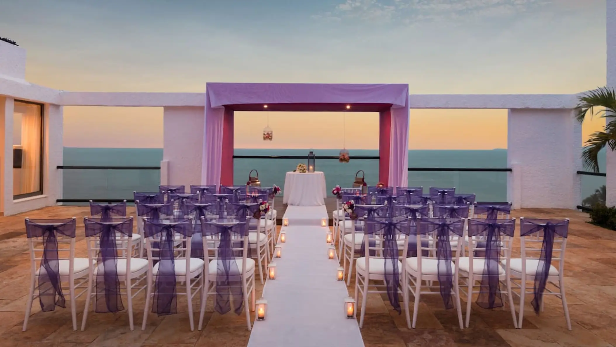 Sky Terrace wedding ceremony setup with purple chairs and sunset ocean views at Hyatt Ziva Puerto Vallarta