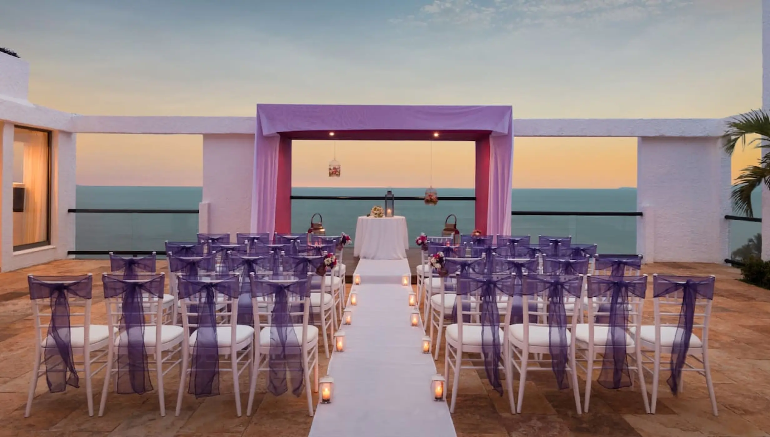Sky Terrace wedding ceremony setup with purple chairs and sunset ocean views at Hyatt Ziva Puerto Vallarta