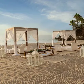 Beachfront wedding reception setup with white cabanas and lanterns at Hyatt Ziva Puerto Vallarta