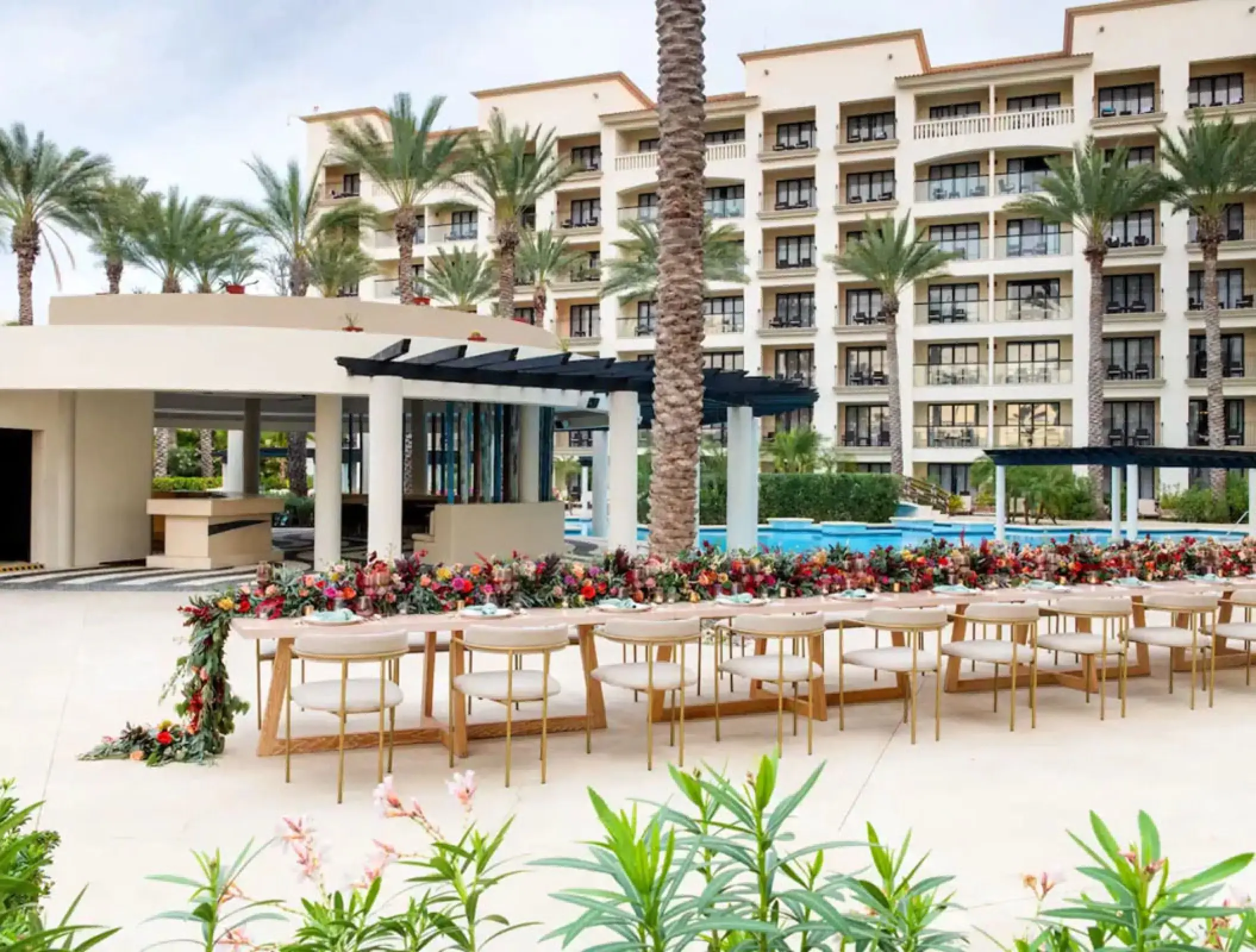 Long wooden wedding reception table with floral runner at Hyatt Ziva Los Cabos, Cabo San Lucas