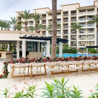 Long wooden wedding reception table with floral runner at Hyatt Ziva Los Cabos, Cabo San Lucas