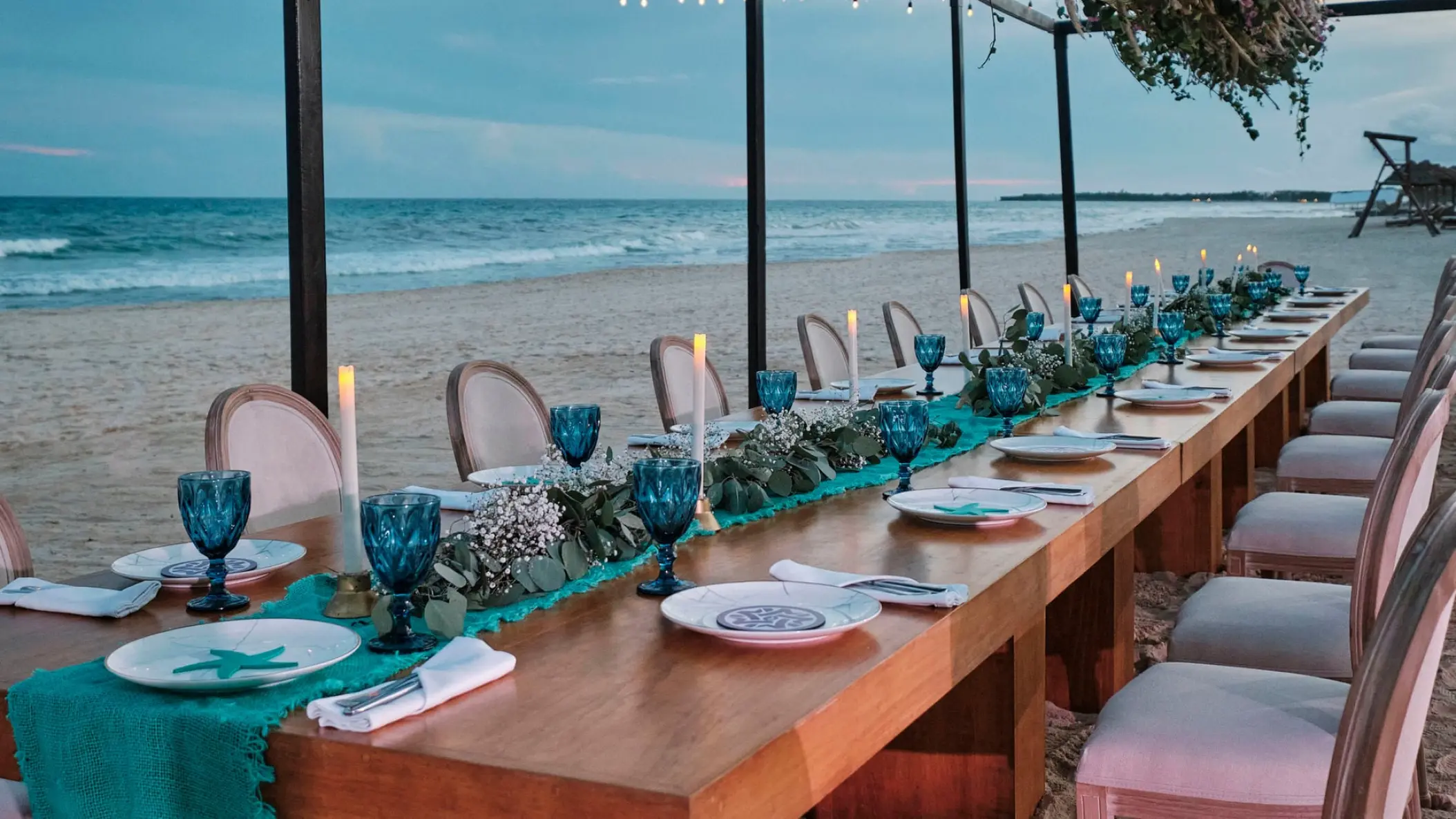 Long wooden wedding reception table on the beach at JOIA Paraiso by Iberostar, Riviera Maya