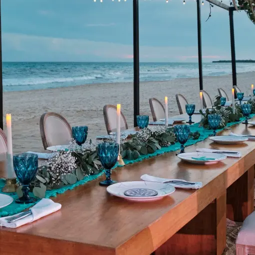 Long wooden wedding reception table on the beach at JOIA Paraiso by Iberostar, Riviera Maya