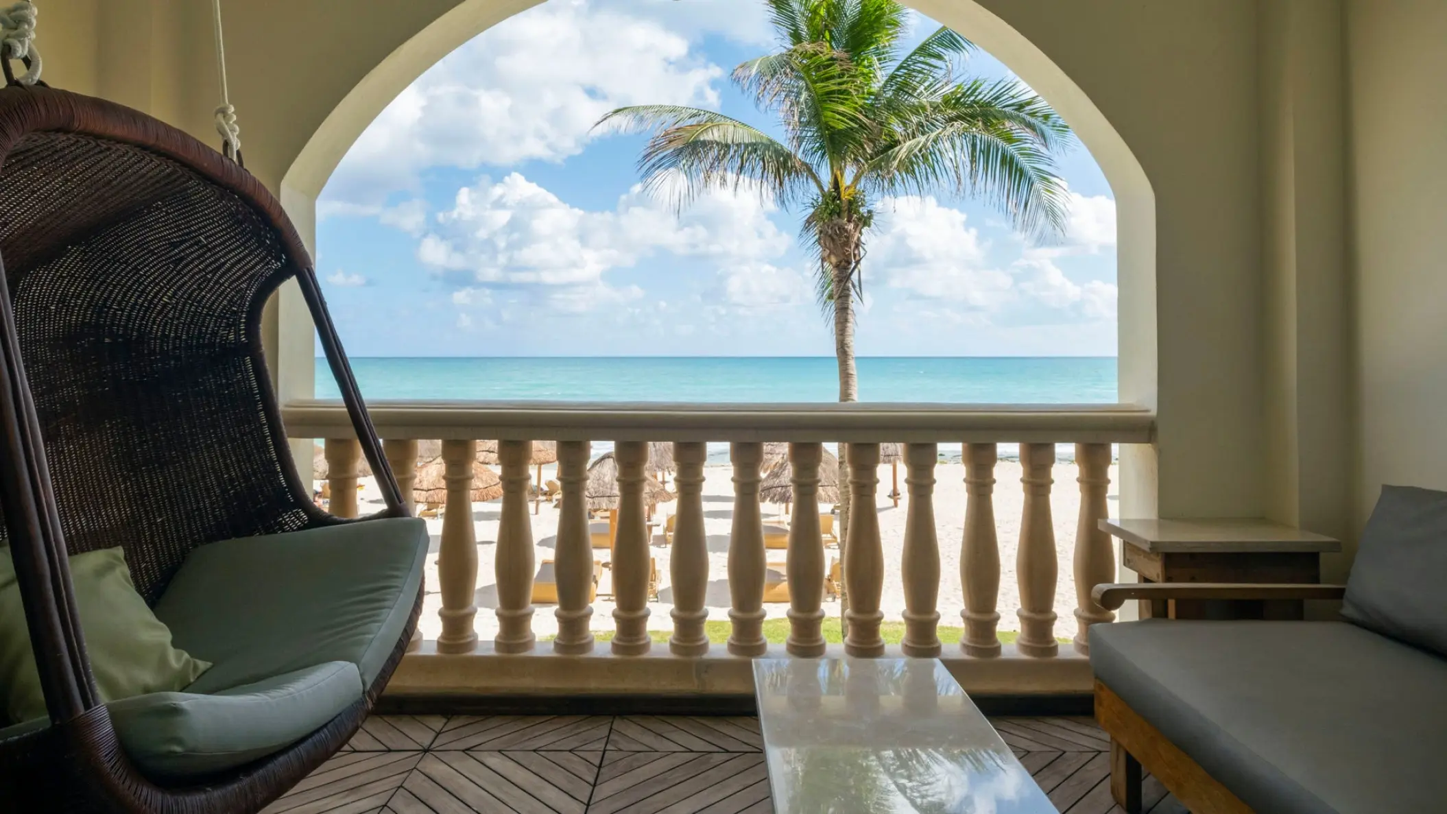 JOIA Paraiso by Iberostar ocean view suite balcony with a hanging chair and palm tree views, Riviera Maya