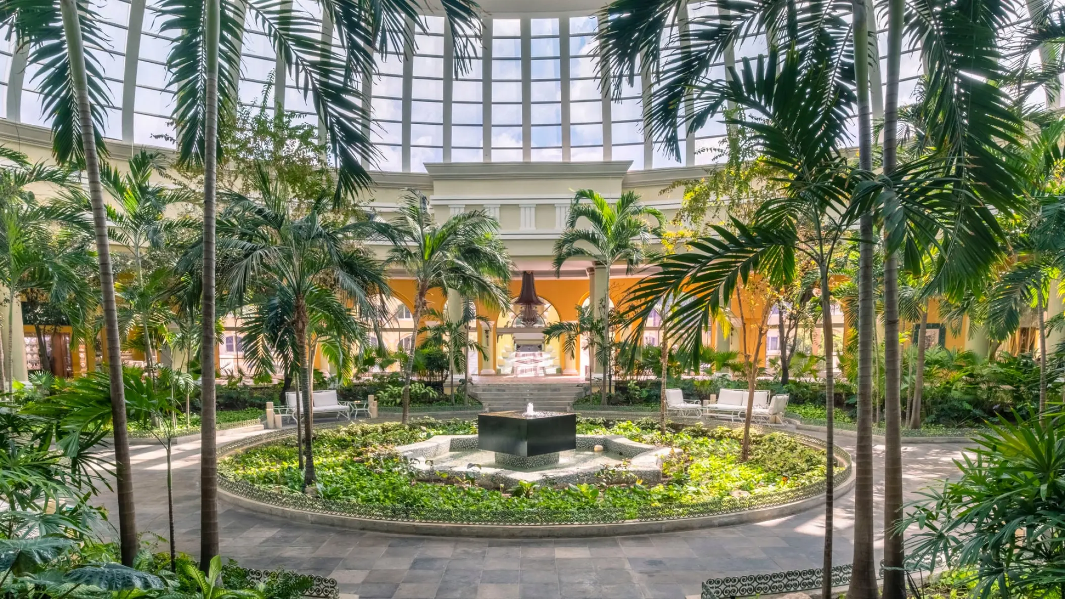 Indoor garden atrium with fountain and palm trees at JOIA Paraiso by Iberostar, Riviera Maya
