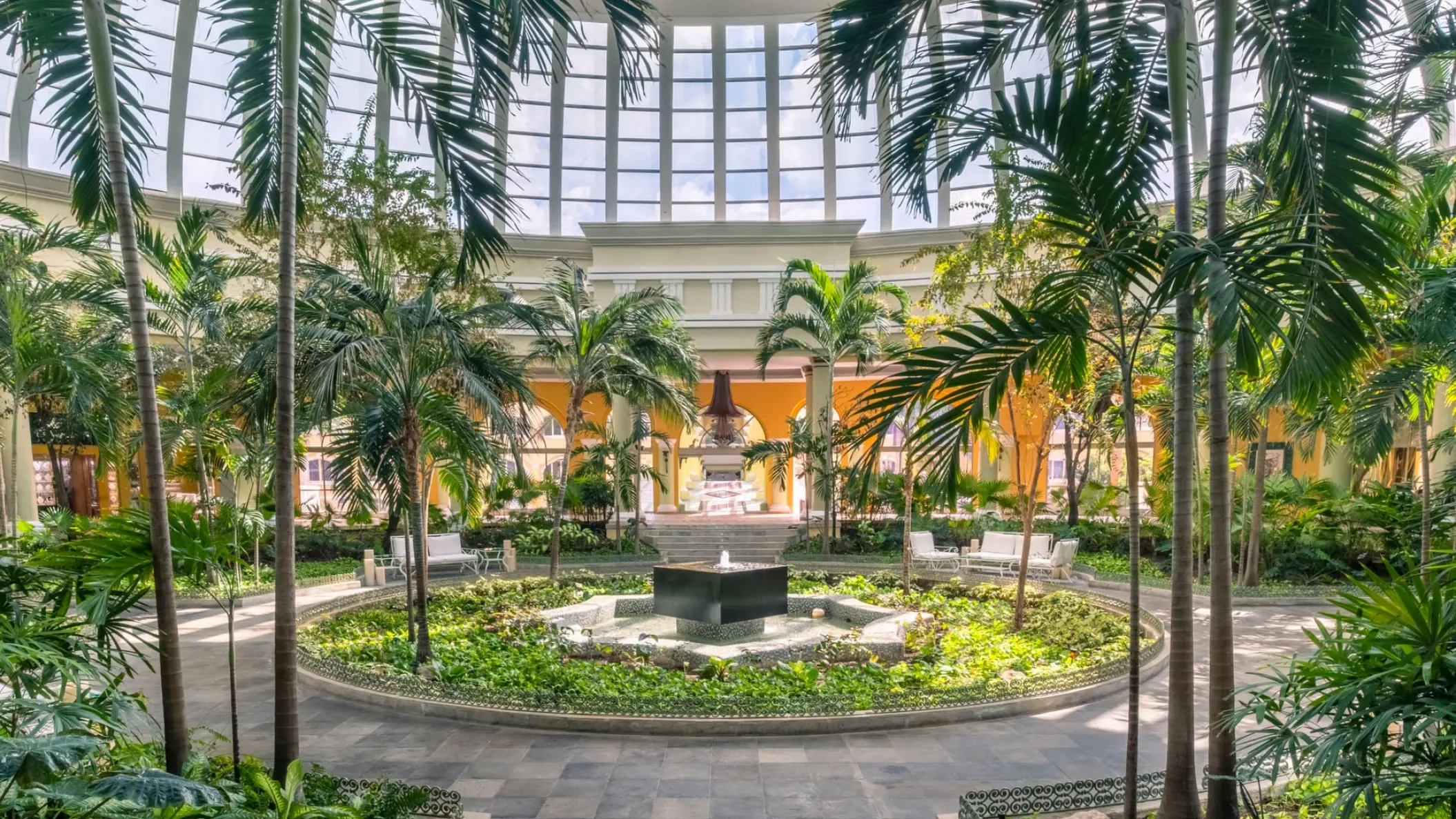 Indoor garden atrium with fountain and palm trees at JOIA Paraiso by Iberostar, Riviera Maya
