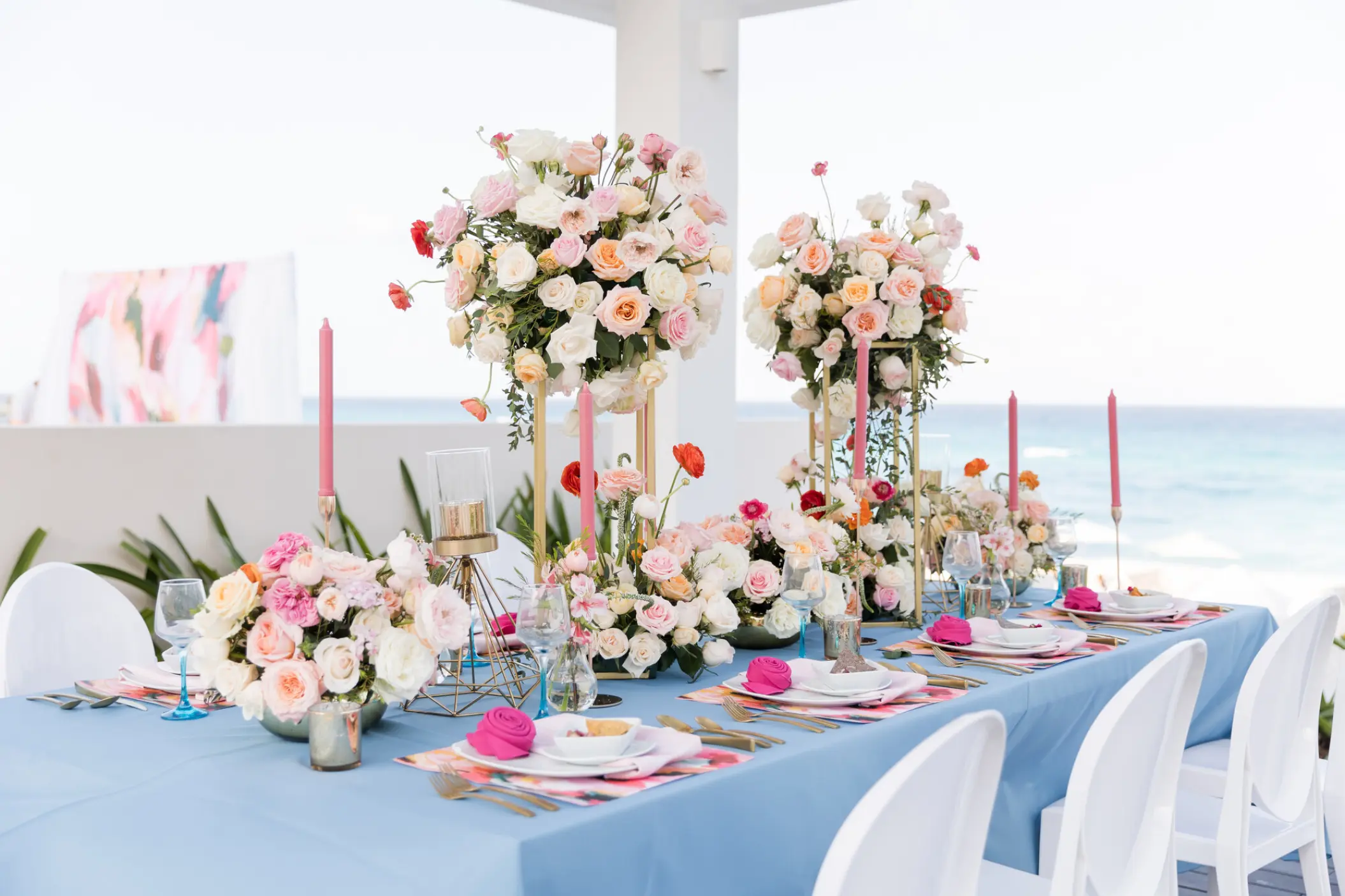 Wedding reception table with blue linens and pink floral centerpieces at Iberostar Selection Cancun