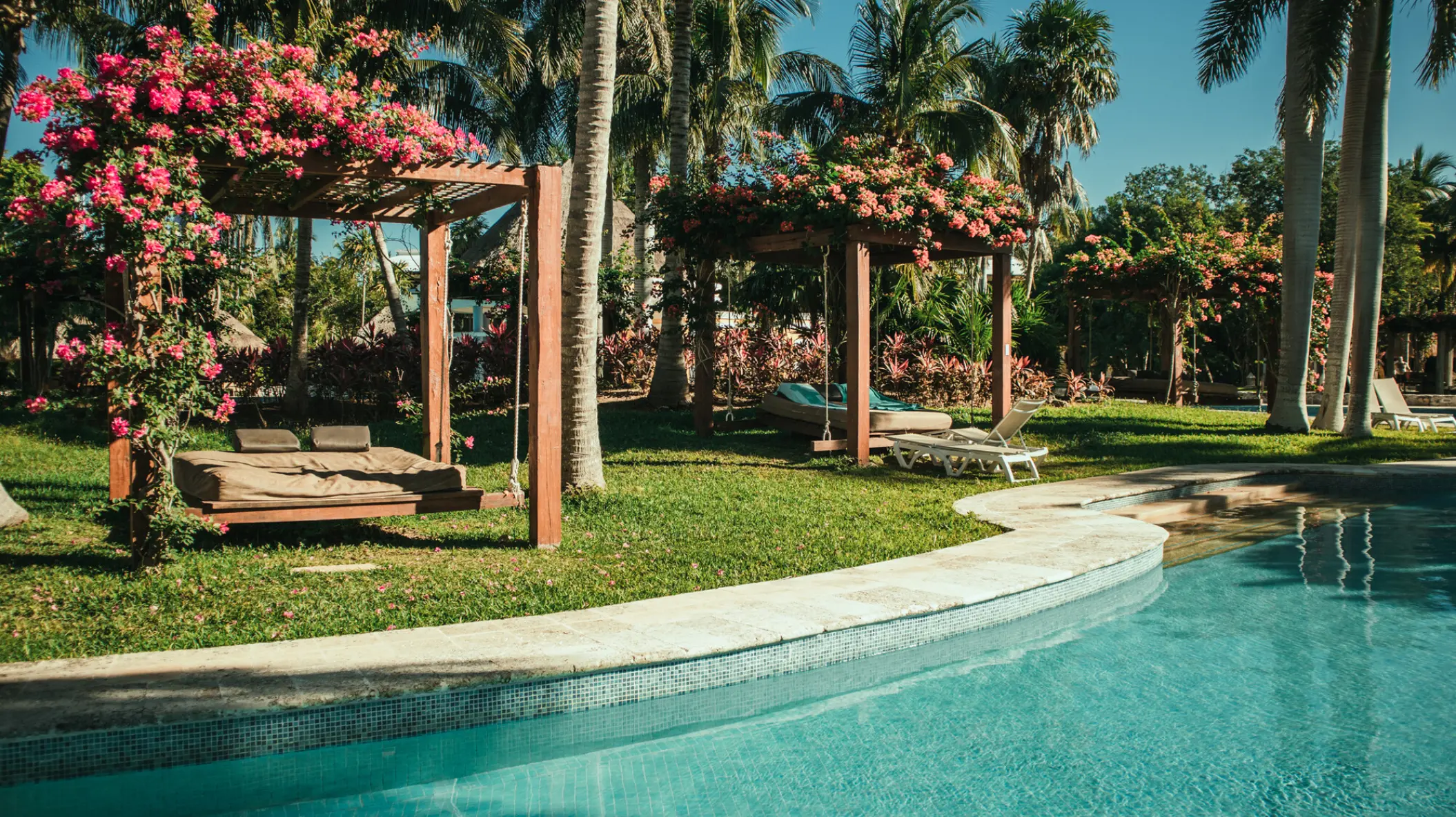 Poolside cabanas covered in pink flowers at Iberostar Waves Paraiso Beach, Riviera Maya