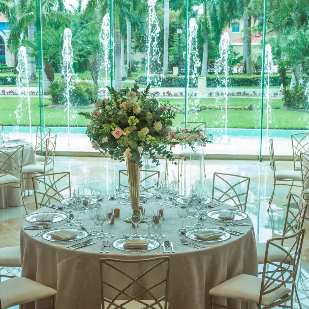 Indoor wedding reception with floral centerpieces and fountain views at Iberostar Paraiso Del Mar, Riviera Maya