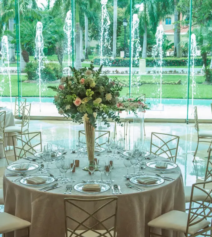 Indoor wedding reception with floral centerpieces and fountain views at Iberostar Paraiso Del Mar, Riviera Maya