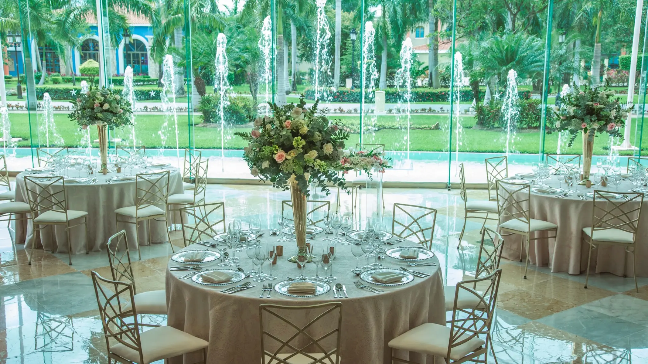 Indoor wedding reception with floral centerpieces and fountain views at Iberostar Paraiso Del Mar, Riviera Maya