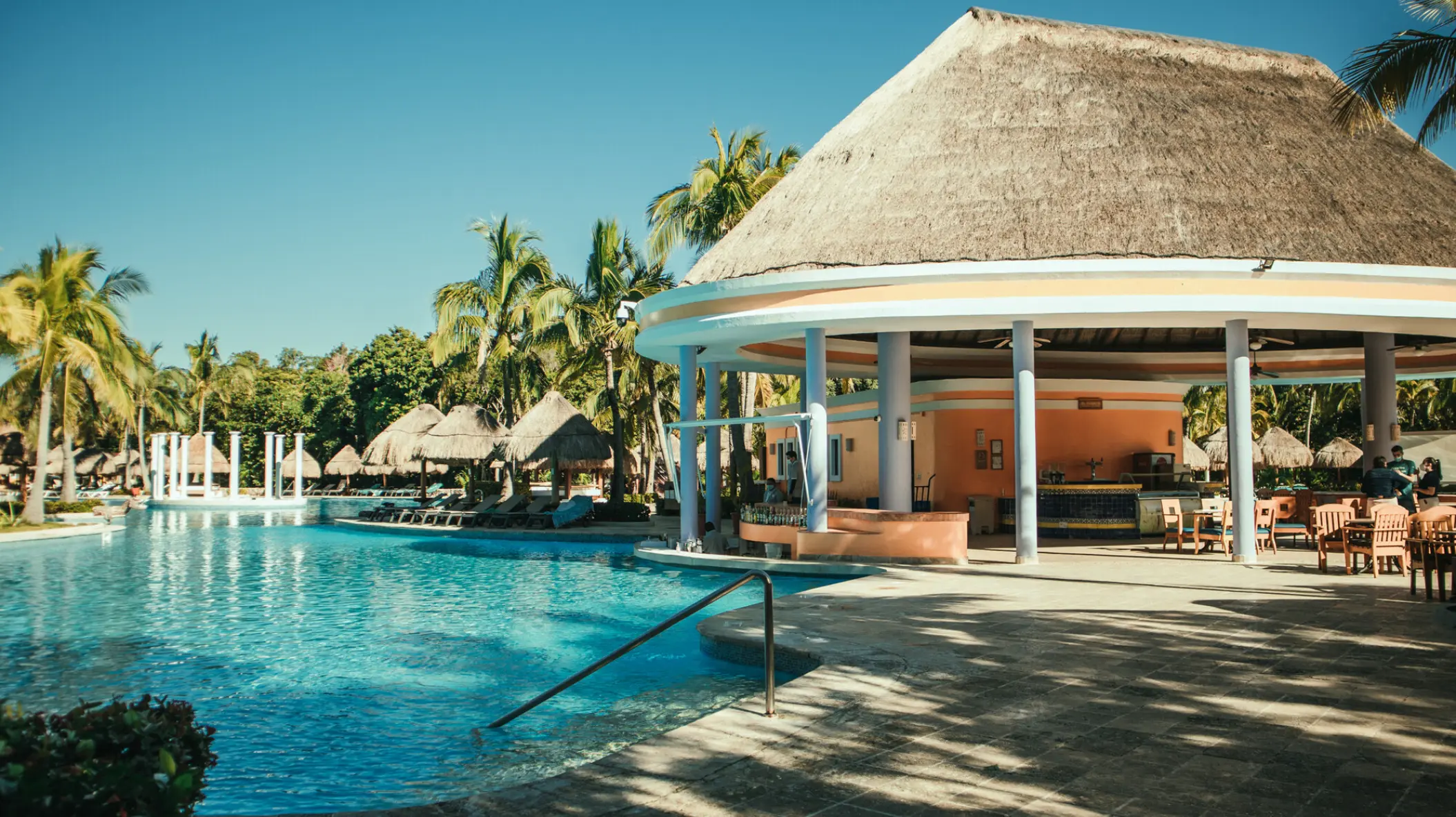 Thatched-roof poolside bar and swimming pool at Iberostar Paraiso Del Mar, Riviera Maya
