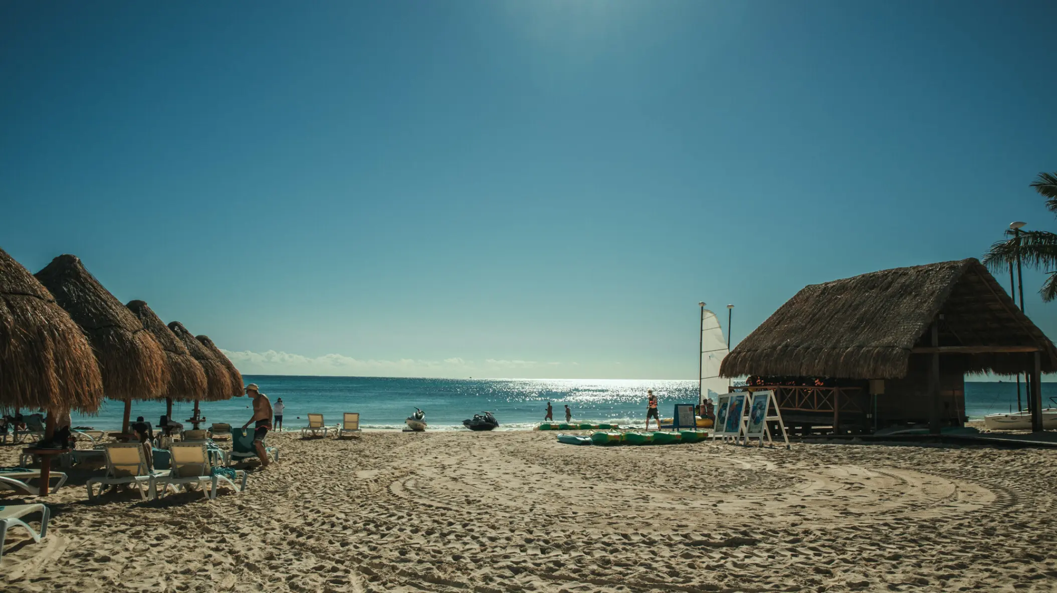 Thatched palapas and sun loungers on the beach at Iberostar Selection Paraiso Maya, Riviera Maya