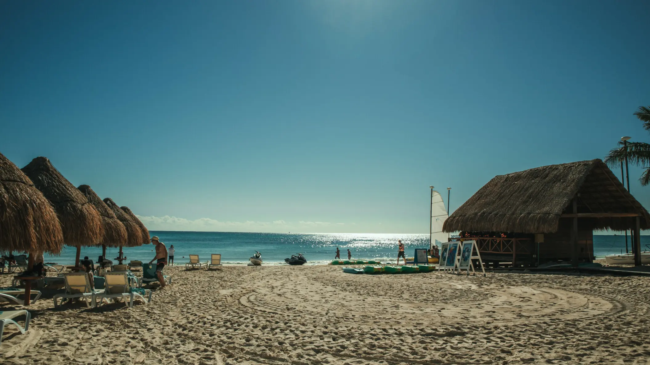 Thatched palapas and sun loungers on the beach at Iberostar Selection Paraiso Maya, Riviera Maya