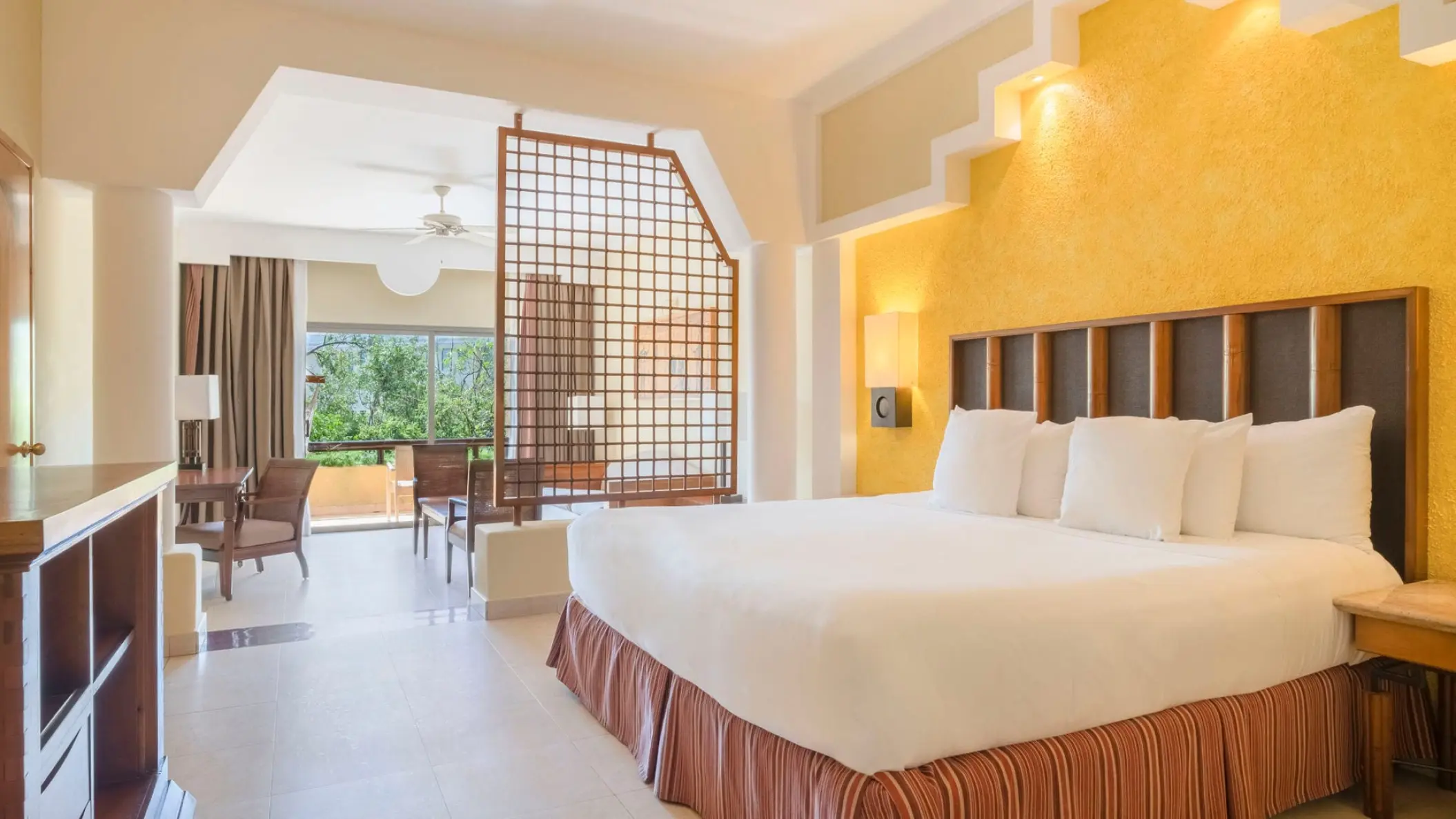 Guest suite with king bed and yellow accent wall at Iberostar Selection Paraiso Maya, Riviera Maya