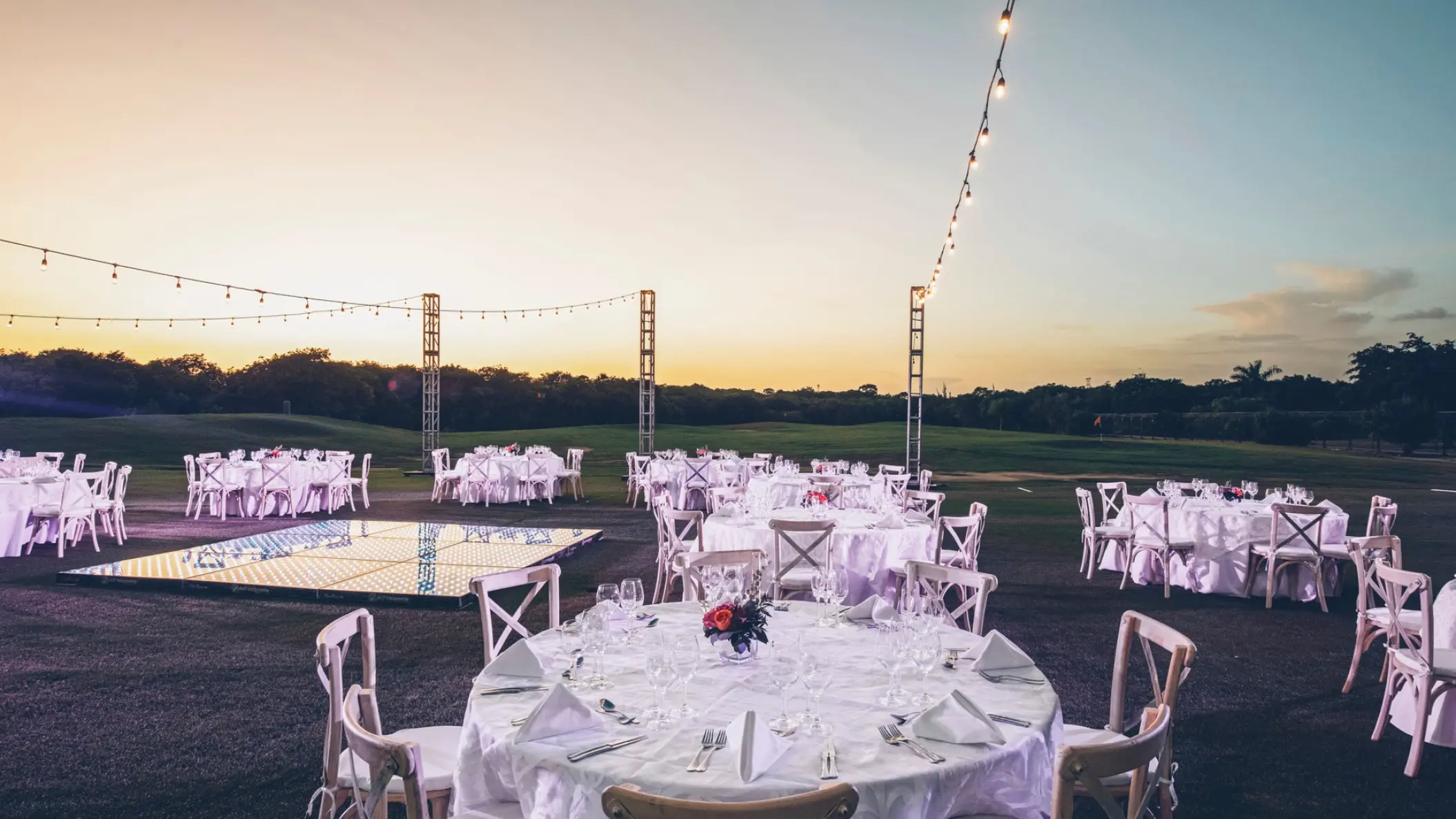 Garden wedding reception with white tables and string lights at Iberostar Paraiso Maya, Riviera Maya
