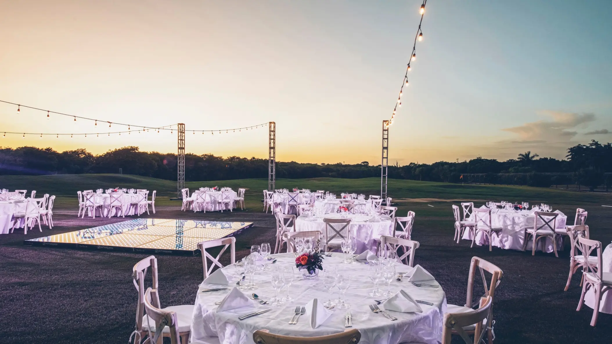 Garden wedding reception with white tables and string lights at Iberostar Paraiso Maya, Riviera Maya