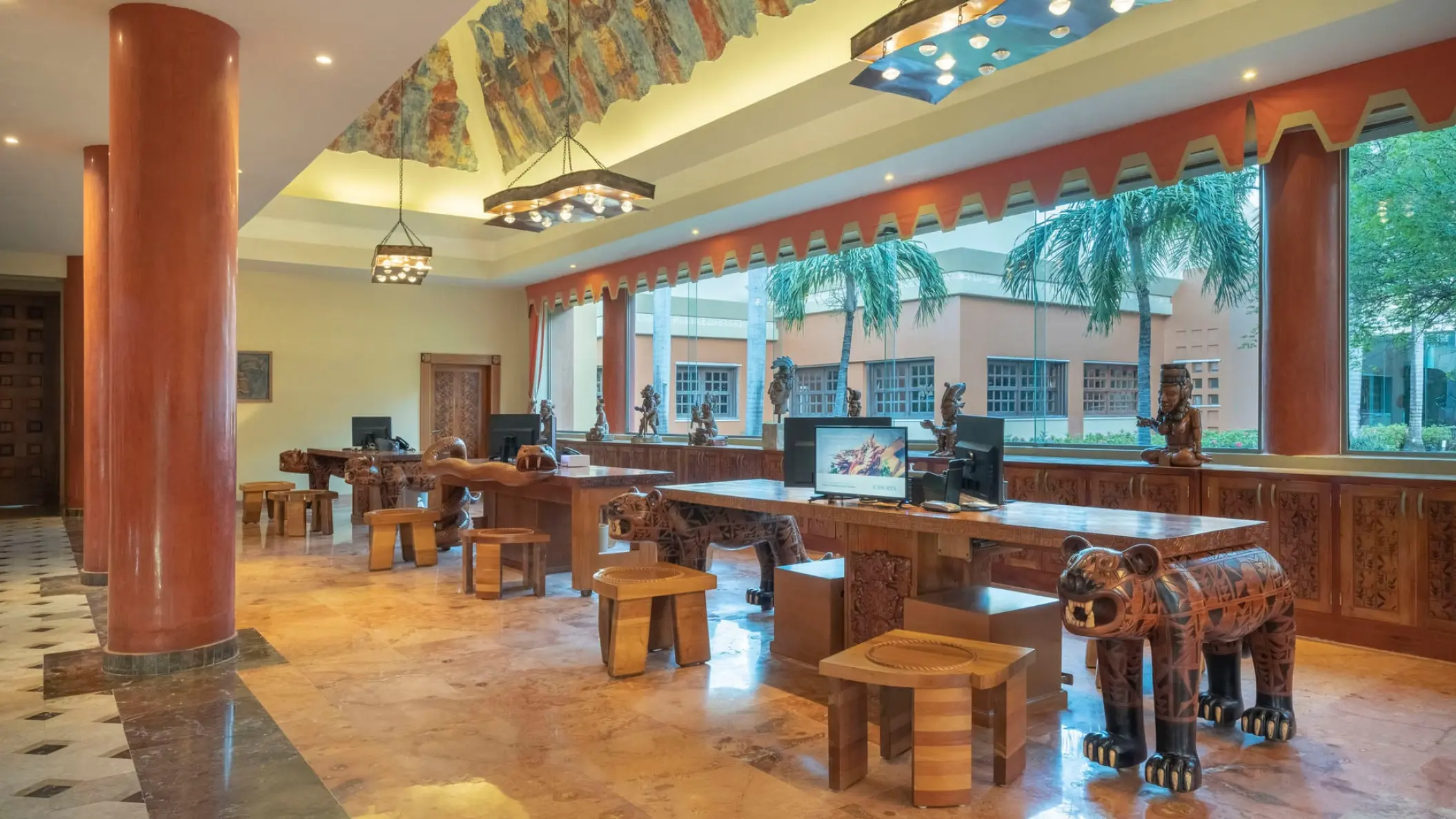 Resort lobby with carved wooden animal statues and mural ceiling at Iberostar Paraiso Maya, Riviera Maya