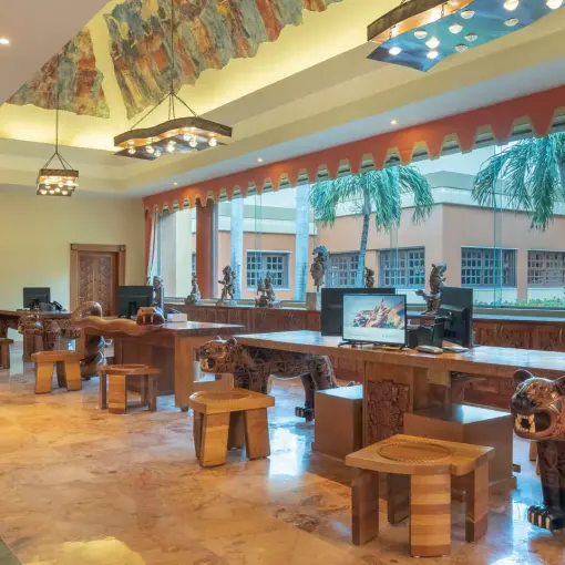 Resort lobby with carved wooden animal statues and mural ceiling at Iberostar Paraiso Maya, Riviera Maya