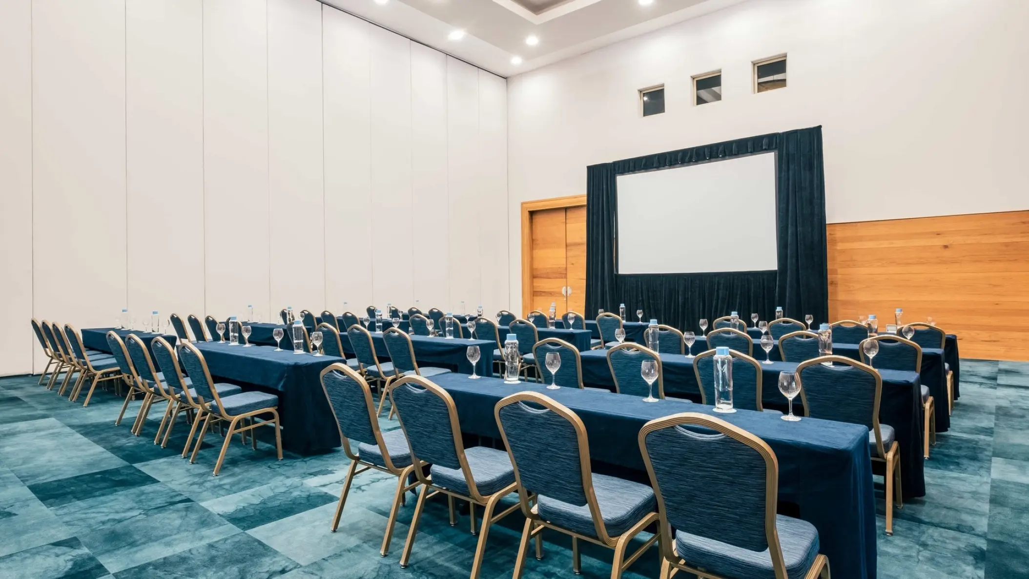 Indoor meeting room with rows of tables and a projection screen at Iberostar Paraiso Maya, Riviera Maya
