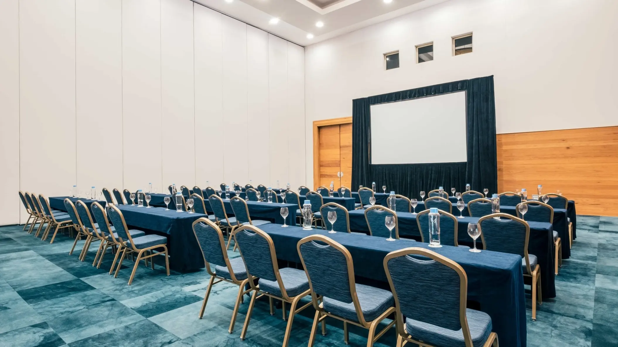 Indoor meeting room with rows of tables and a projection screen at Iberostar Paraiso Maya, Riviera Maya