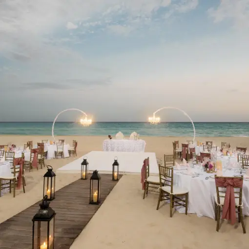 Beachfront wedding reception setup with lanterns and chandeliers at Iberostar Waves Quetzal, Playa Del Carmen