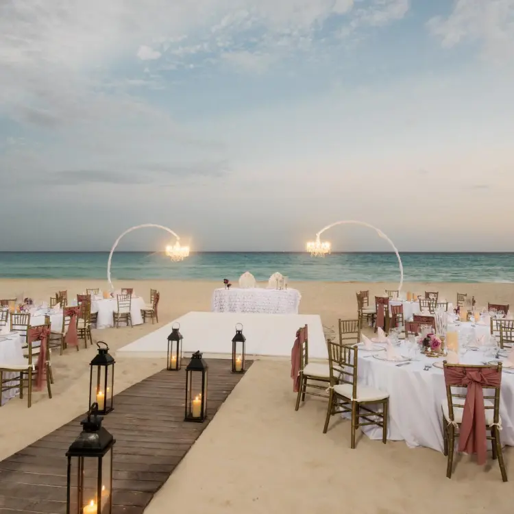 Beachfront wedding reception setup with lanterns and chandeliers at Iberostar Waves Quetzal, Playa Del Carmen