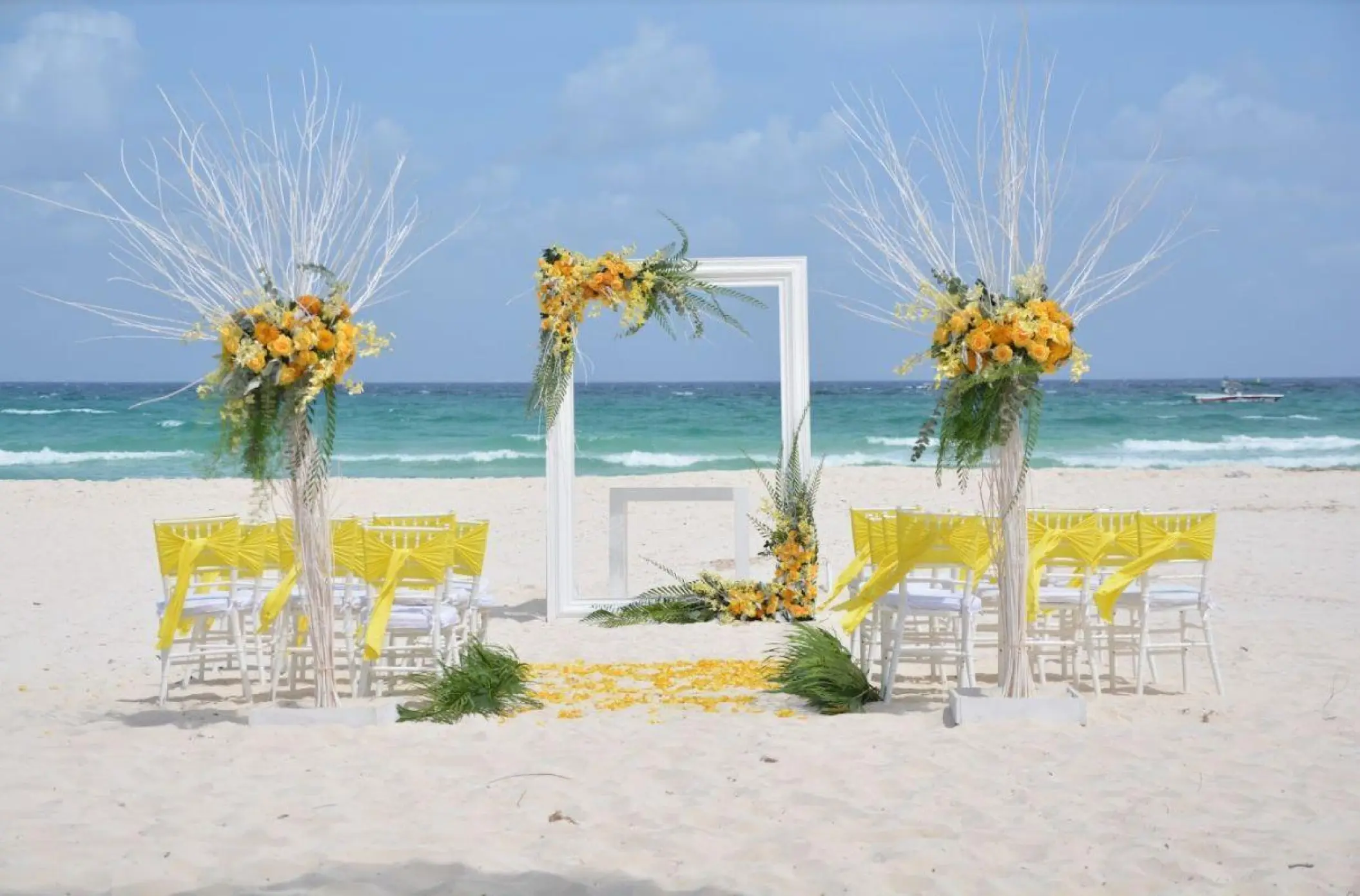 Beachfront wedding ceremony with yellow floral decor at Iberostar Waves Quetzal, Playa Del Carmen