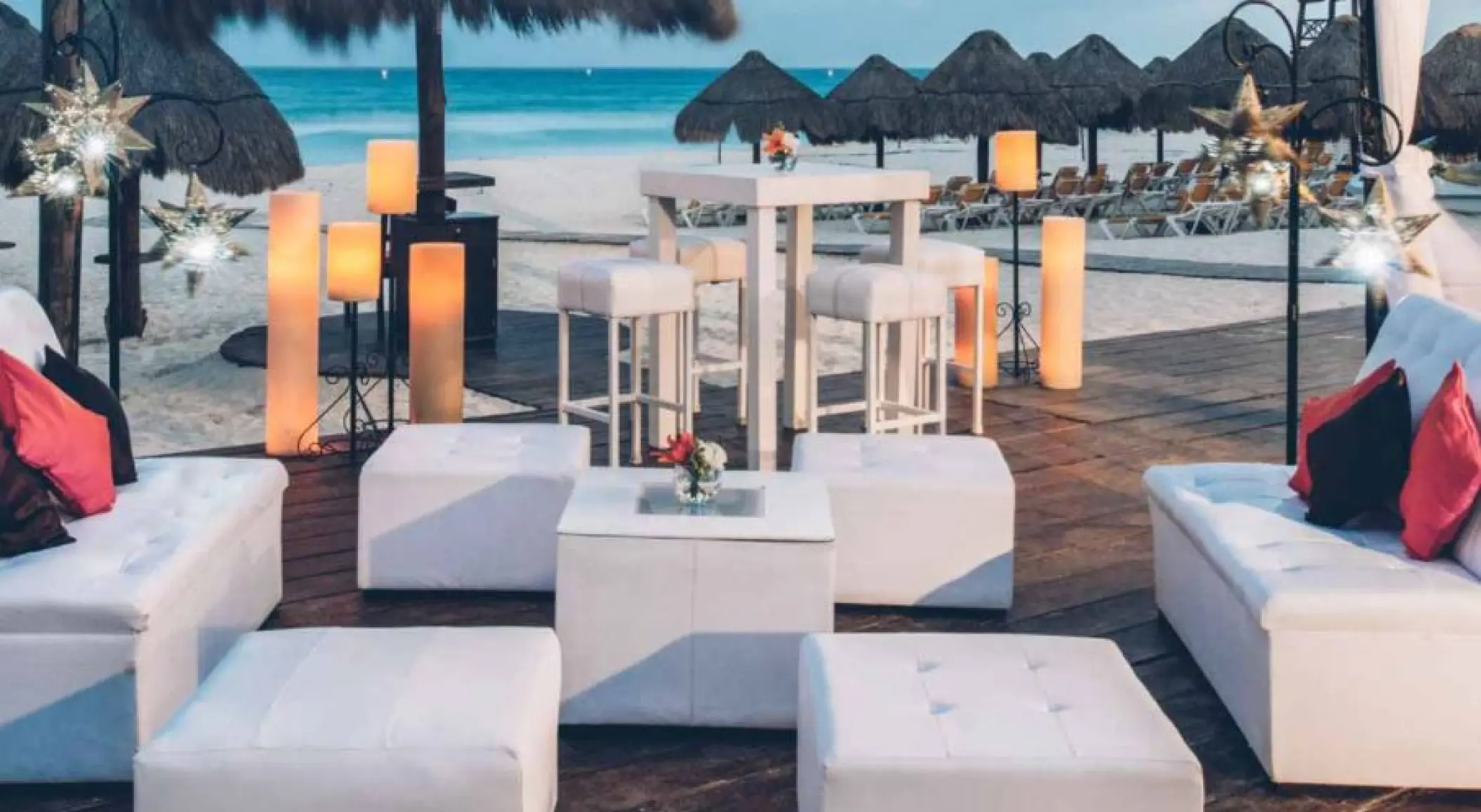 Beachfront wedding lounge setup with white furniture and lanterns at Iberostar Waves Quetzal, Playa Del Carmen