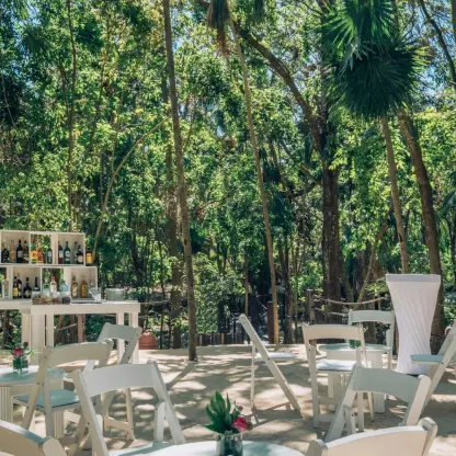 Garden wedding reception with white chairs and bar at Iberostar Waves Quetzal, Playa Del Carmen