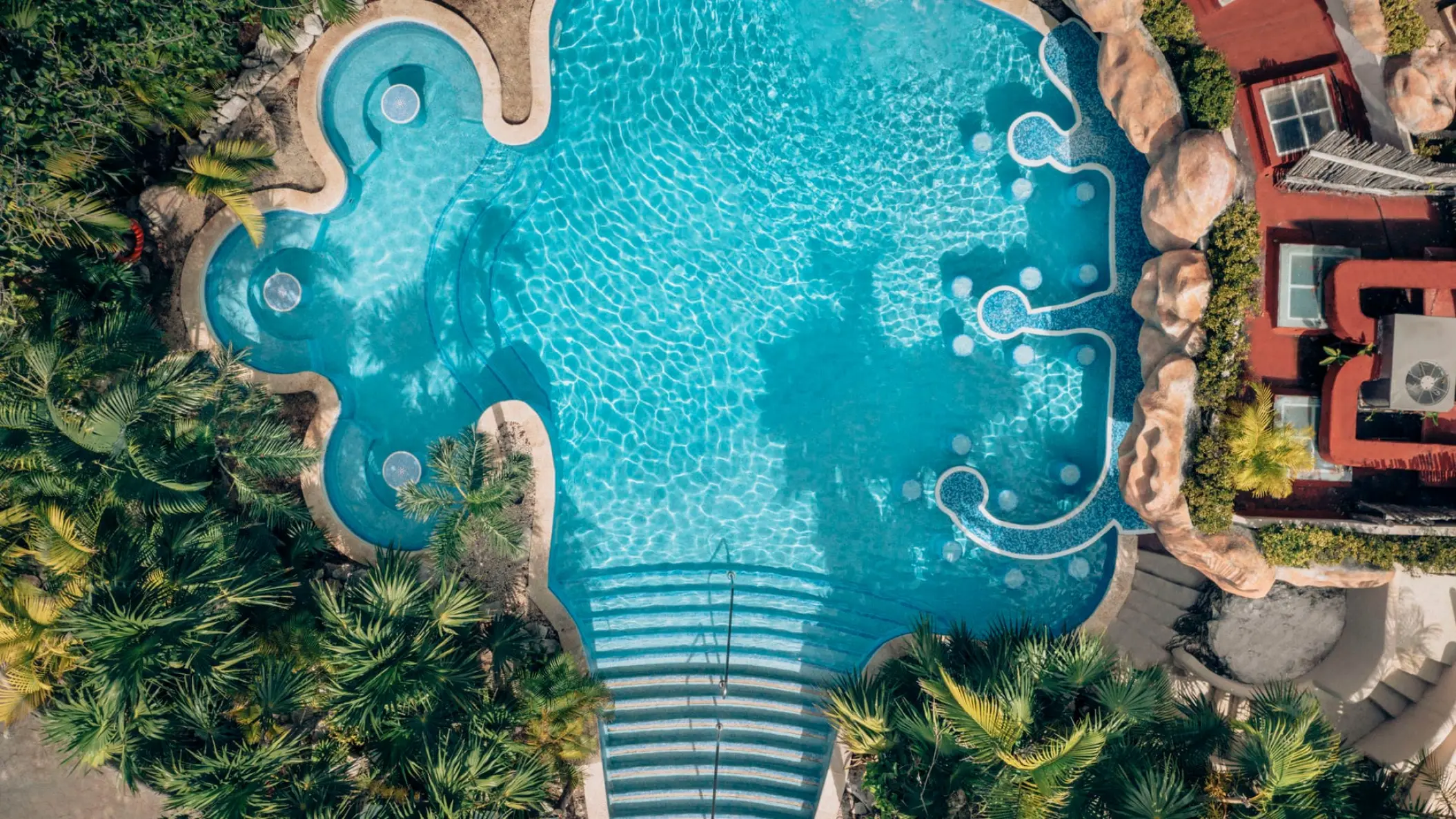 Aerial view of the main swimming pool and swim-up bar at Iberostar Waves Quetzal, Playa Del Carmen