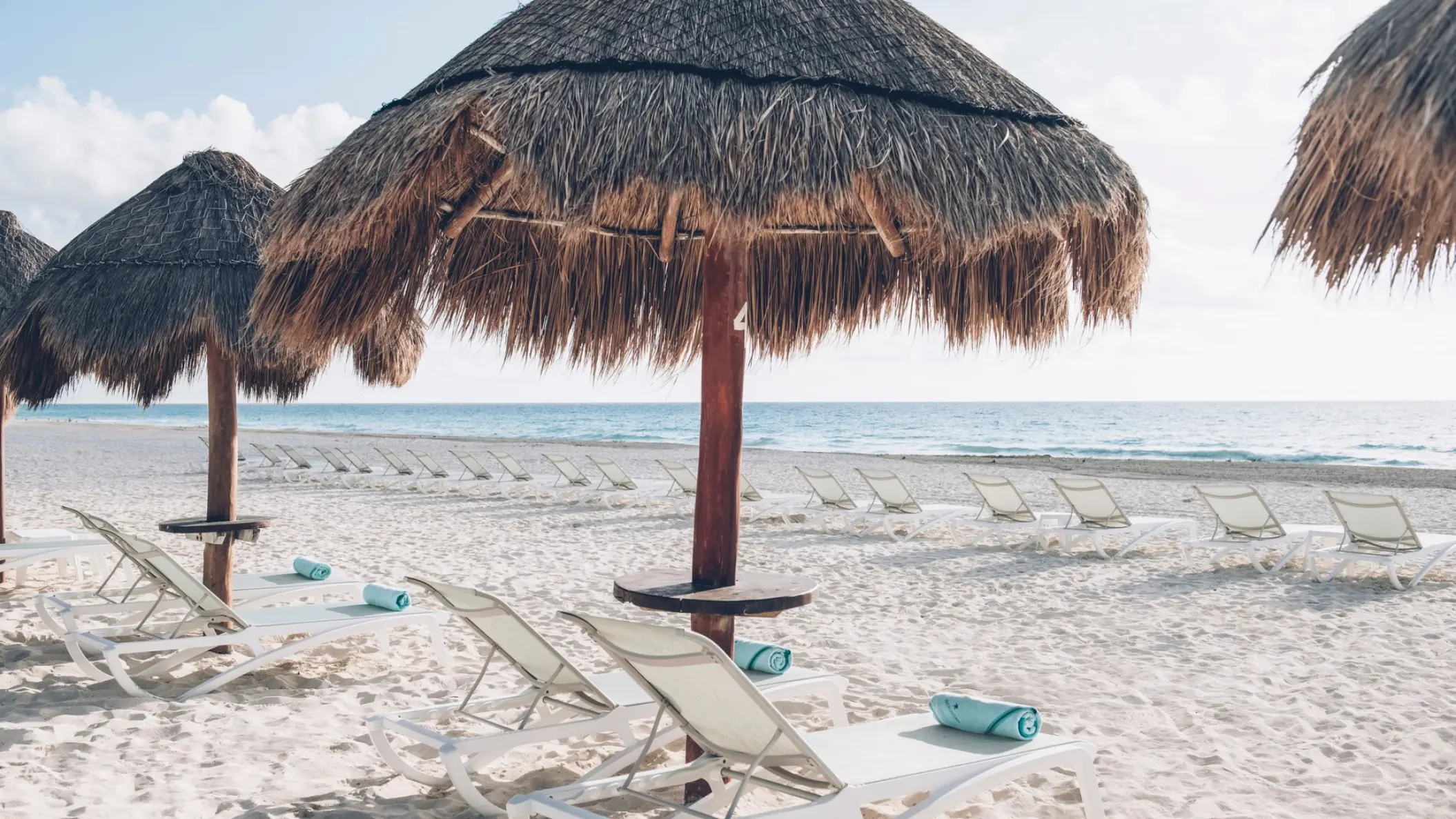 Palapa umbrellas and sun loungers on the beach at Iberostar Selection Cancun