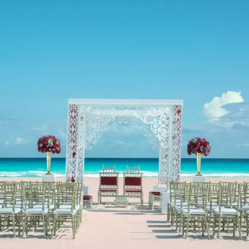 Beachfront wedding ceremony with a white laser-cut gazebo at Iberostar Selection Cancun