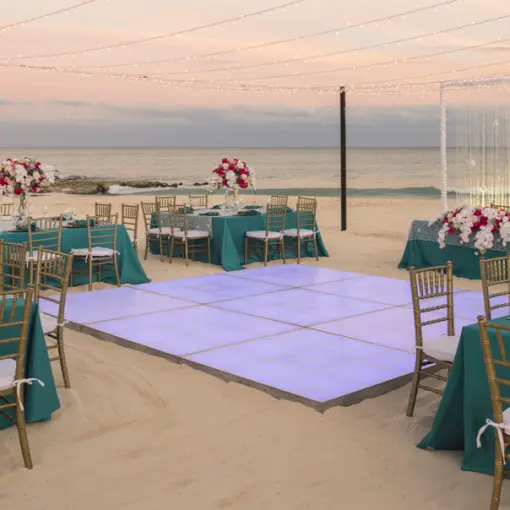 Beachfront wedding reception with dance floor and string lights at Iberostar Selection Cancun