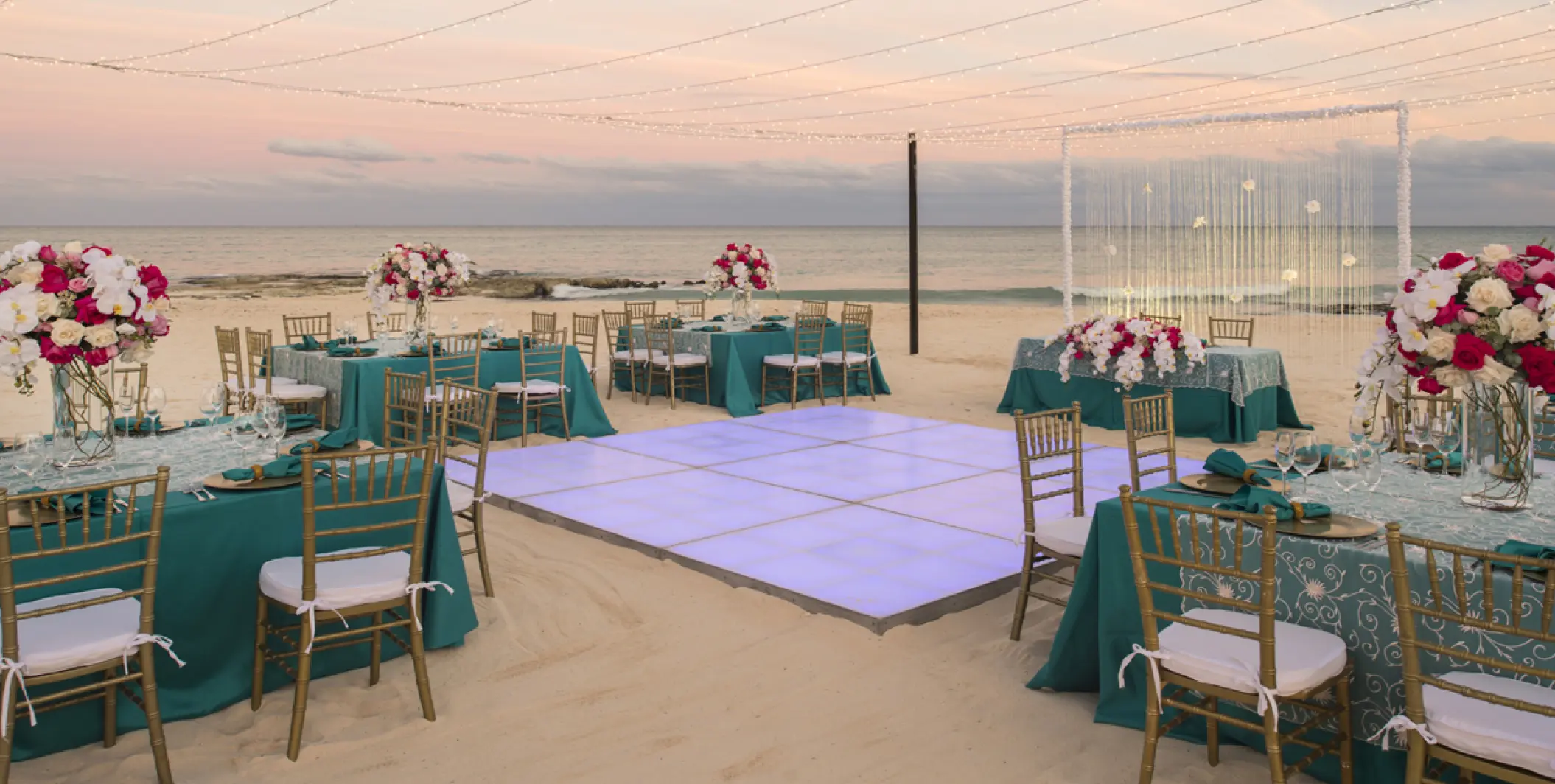 Beachfront wedding reception with dance floor and string lights at Iberostar Selection Cancun