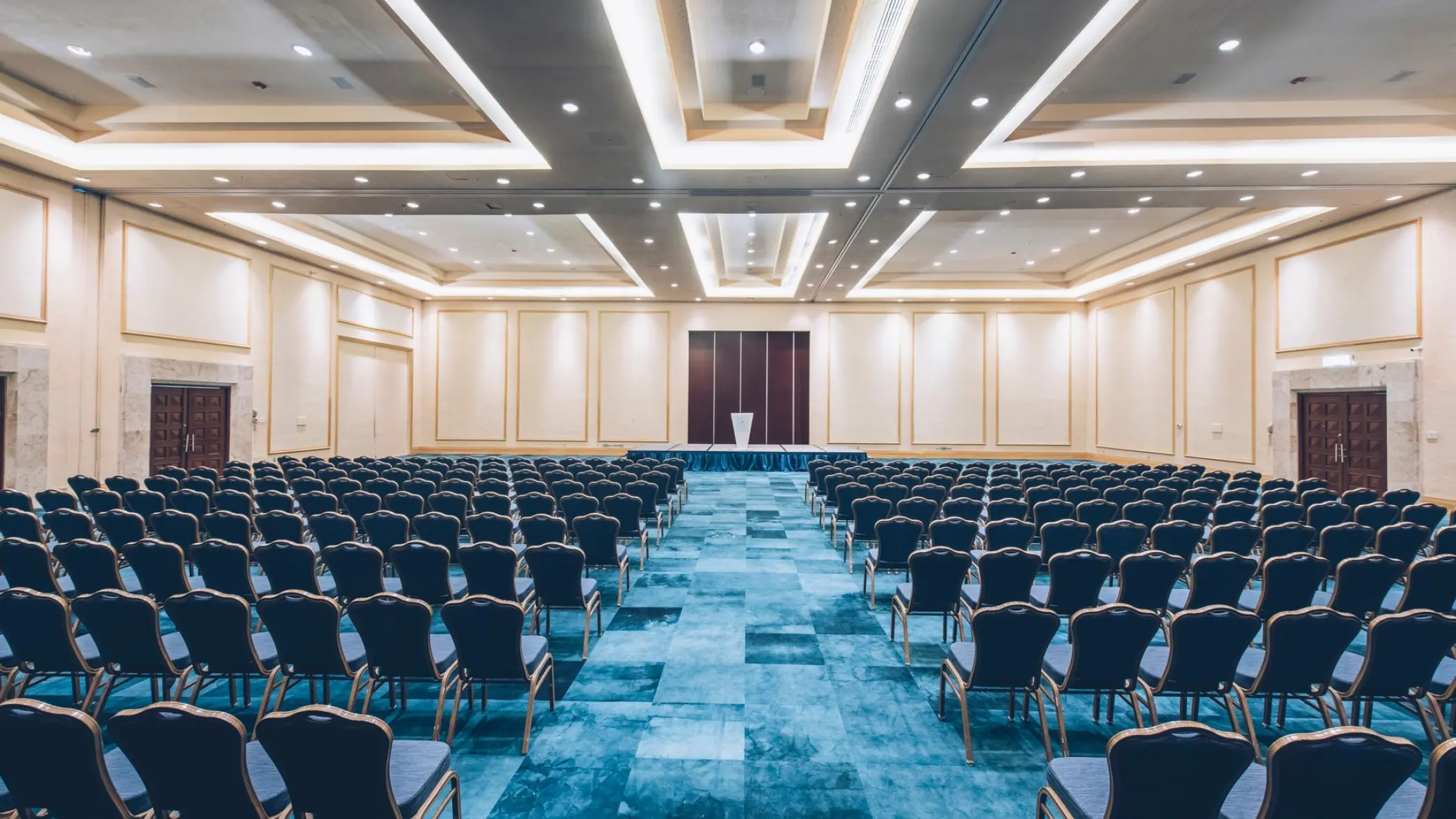 Iberostar Selection Cancun convention center with rows of blue chairs and a podium, Cancun