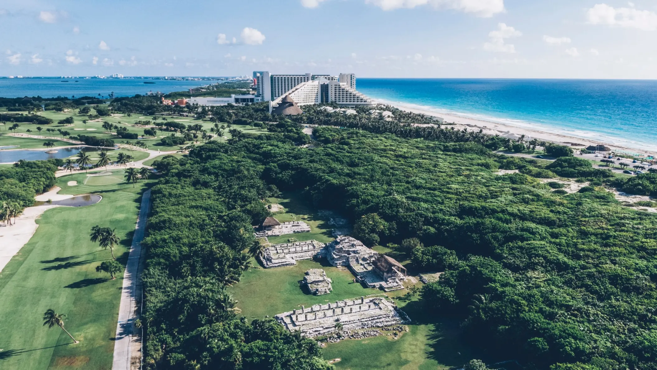 Aerial view of Iberostar Selection Cancun grounds showing the golf course, ruins, and beach, Cancun