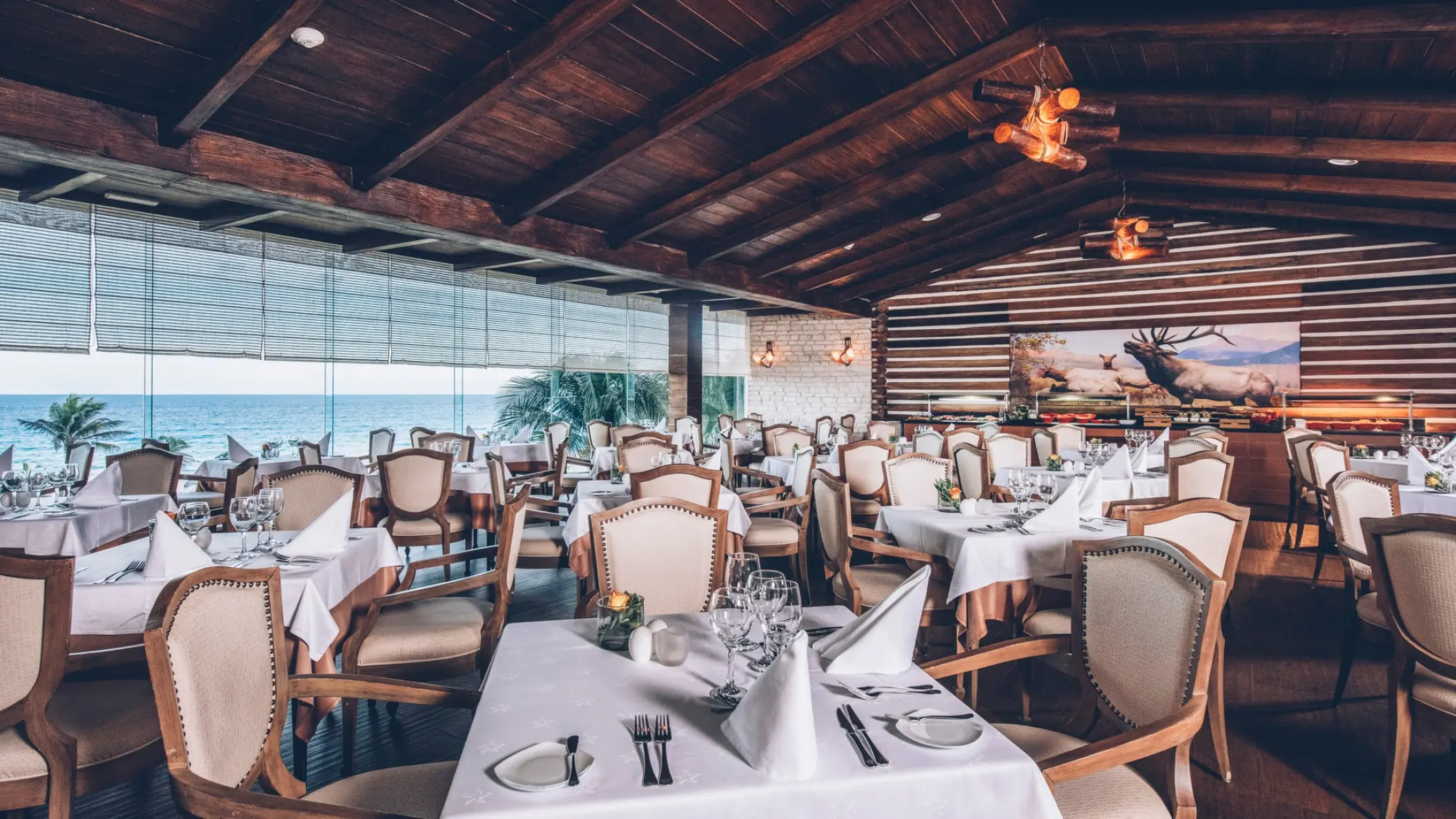 Indoor restaurant with white tablecloths and ocean views at Iberostar Selection Cancun