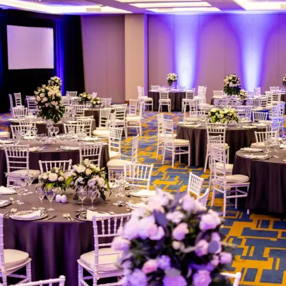 Indoor wedding reception with purple lighting and white floral centerpieces at Iberostar Selection Playa Mita