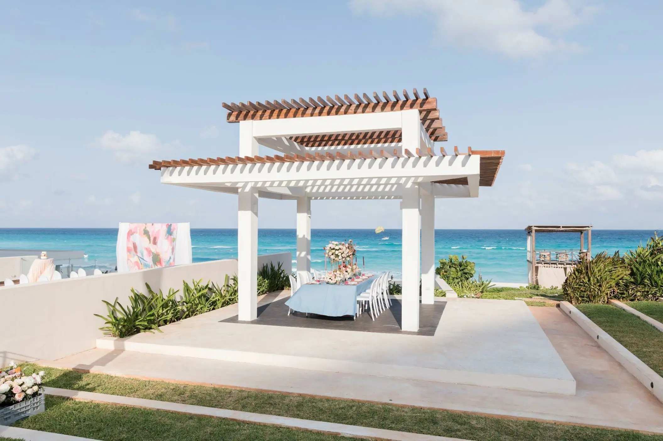 White pergola wedding reception setup overlooking the ocean at Iberostar Selection Cancun